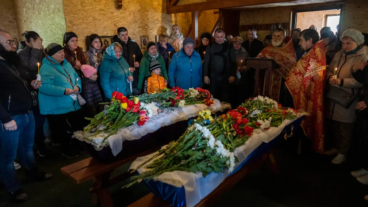 Relatives and family friends attend the funeral of Sofia Shulha, 12, and Pysarev Kiriusha, 18, in Uman, central Ukraine, Sunday, April 30, 2023. Shulha and Kiriusha were killed during a Russian attack on a residential building early Friday morning. (AP Photo/Bernat Armangue)