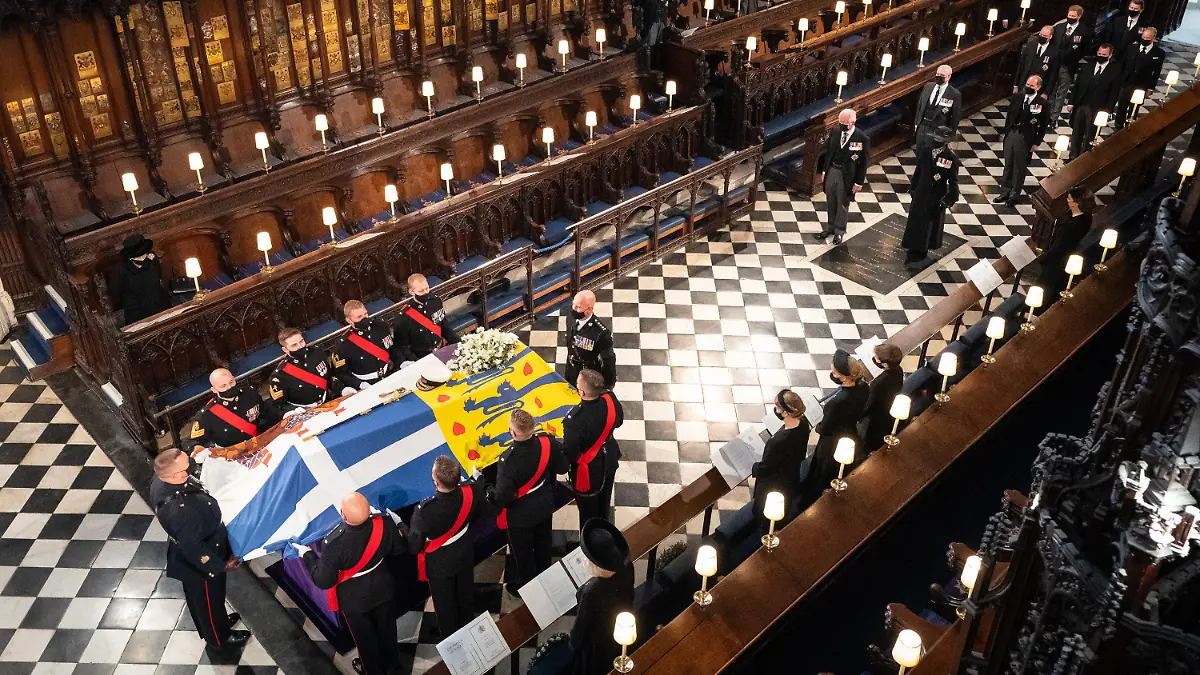 19.01.2021, Großbritannien, London: Königin Elizabeth II. (l) sieht zu, wie Sargträger den Sarg von Prinz Philip zur Beisetzung in die St.-Georgs-Kapelle bringen. Auf dem Sarg liegen das Schwert des Herzog von Edinburghs und seine Admiralsmütze. Hinter dem Sarg stehen ihre vier Kinder Prinz Charles, Prinzessin Anne, Prinz Andrew und Prinz Edward, die Enkelsöhne Prinz William, Prinz Harry, Peter Peter Phillips sowie David Armstrong-Jones und Sir Timothy Laurence. Prinz Philip war am 9. April im Alter von 99 Jahren gestorben. (zu dpa "Vereint auf Distanz - Royals nehmen Abschied von Prinz Philip") Foto: Dominic Lipinski/PA Wire/dpa +++ dpa-Bildfunk +++