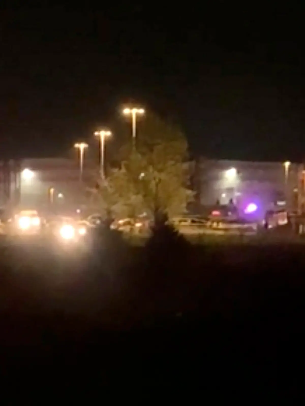 SCREENSHOT - 16.04.2021, USA, Indianapolis: Dieser Auszug aus einem Video zeigt ein breites Gebäude mit blinkenden Lichtern von Einsatzfahrzeugen. Bei Schüssen in einem Paketzentrum des Logistikunternehmens Fedex in den USA sind Medienberichten zufolge mindestens acht Menschen ums Leben gekommen. Foto: Uncredited/WRTV/AP/dpa +++ dpa-Bildfunk +++