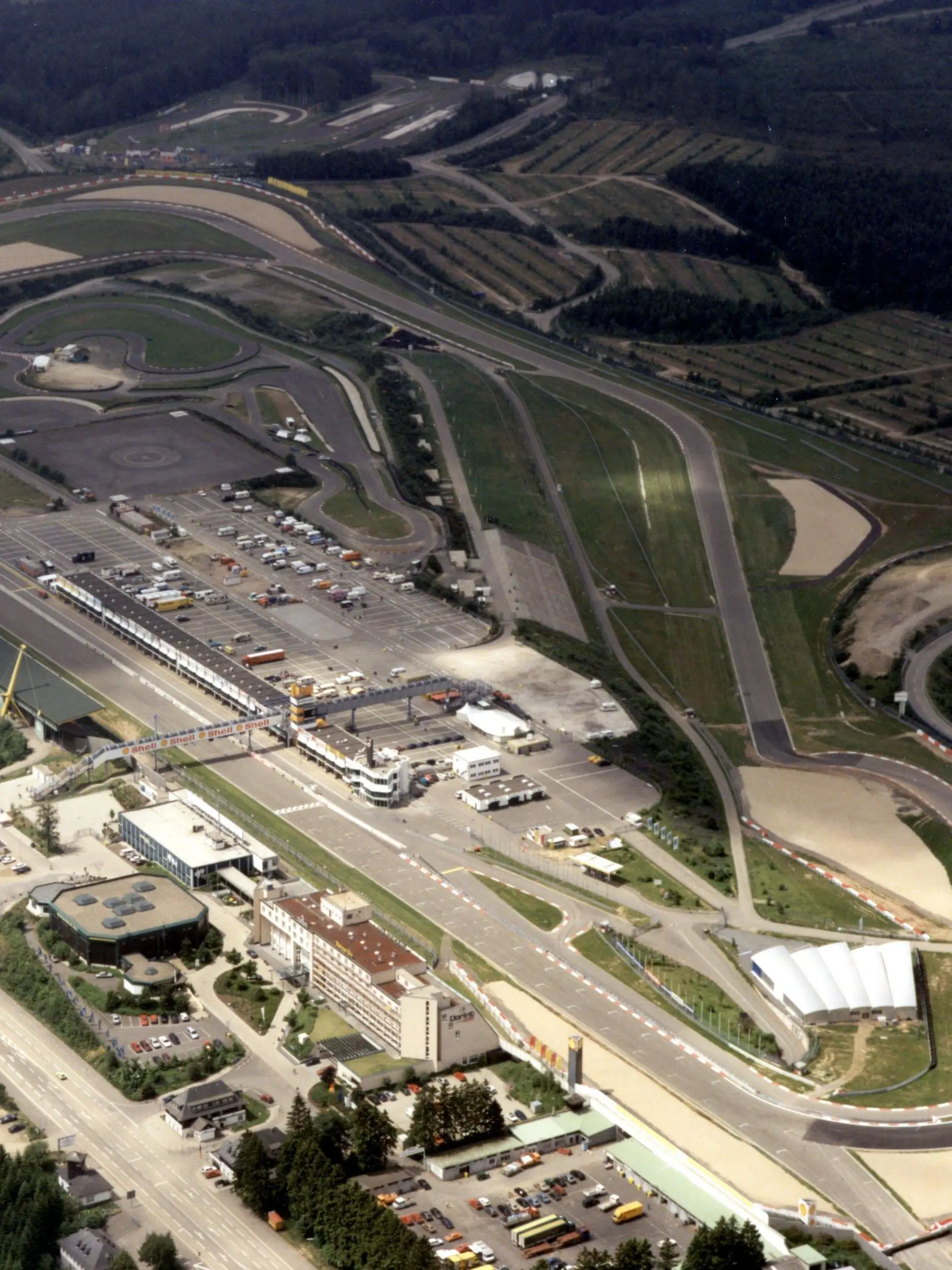 Ausschnitt des Nürburgrings in der Eifel in einer Luftaufnahme (undatiertes Archivfoto). Der Bau einer neuen Erlebnisregion am Nürburgring soll nach der Saison 2007 beginnen. Die Bauzeit beträgt etwa zwei Jahre, bekräftigte der Geschäftsführer der Nürburgring GmbH, Walter Kafitz, am Dienstag (27.09.2005) bei einer Feier zur Erinnerung an die Grundsteinlegung der legendären Rennstrecke vor 80 Jahren auf der Nürburg (Kreis Ahrweiler). Bis zu 200 Millionen Euro will die Nürburgring GmbH zusammen mit privaten Geldgebern in das Projekt investieren, das die Strecke unabhängiger vom Motorsport machen soll. Foto: Elmar Hartmann dpa/lrs (zu lrs 7356 vom 27.09.2005) +++(c) dpa - Bildfunk+++