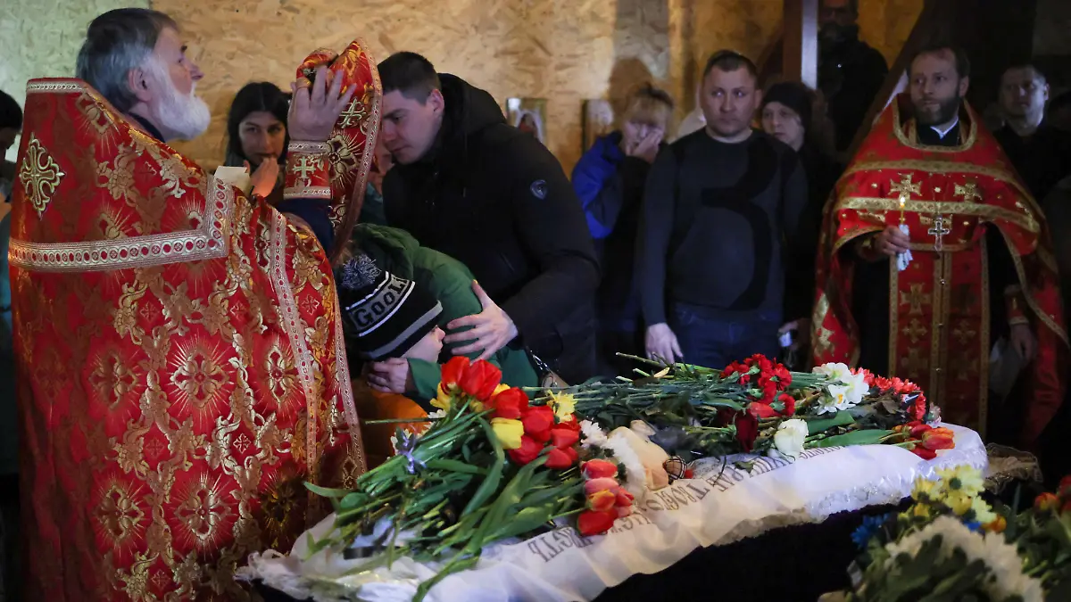 People pay respects during the funeral of two children, Sofia and Kyrylo, who officials said were killed on Friday by a Russian missile strike, amid Russia's attack on Ukraine, in the town of Uman, Cherkasy region, Ukraine April 30, 2023. REUTERS/Carlos Barria