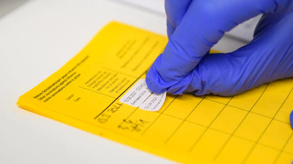 03.04.2021, Nordrhein-Westfalen, Velen: Informationen über die Impfung werden im Impfpass eingetragen. Menschen ab 60 Jahren können ab heute in Nordrhein-Westfalen einen Termin zur Impfung mit dem Wirkstoff von Astrazeneca vereinbaren. Die ersten Über-60-Jährigen wurden sogar schon heute geimpft. Foto: Christopher Neundorf/dpa +++ dpa-Bildfunk +++