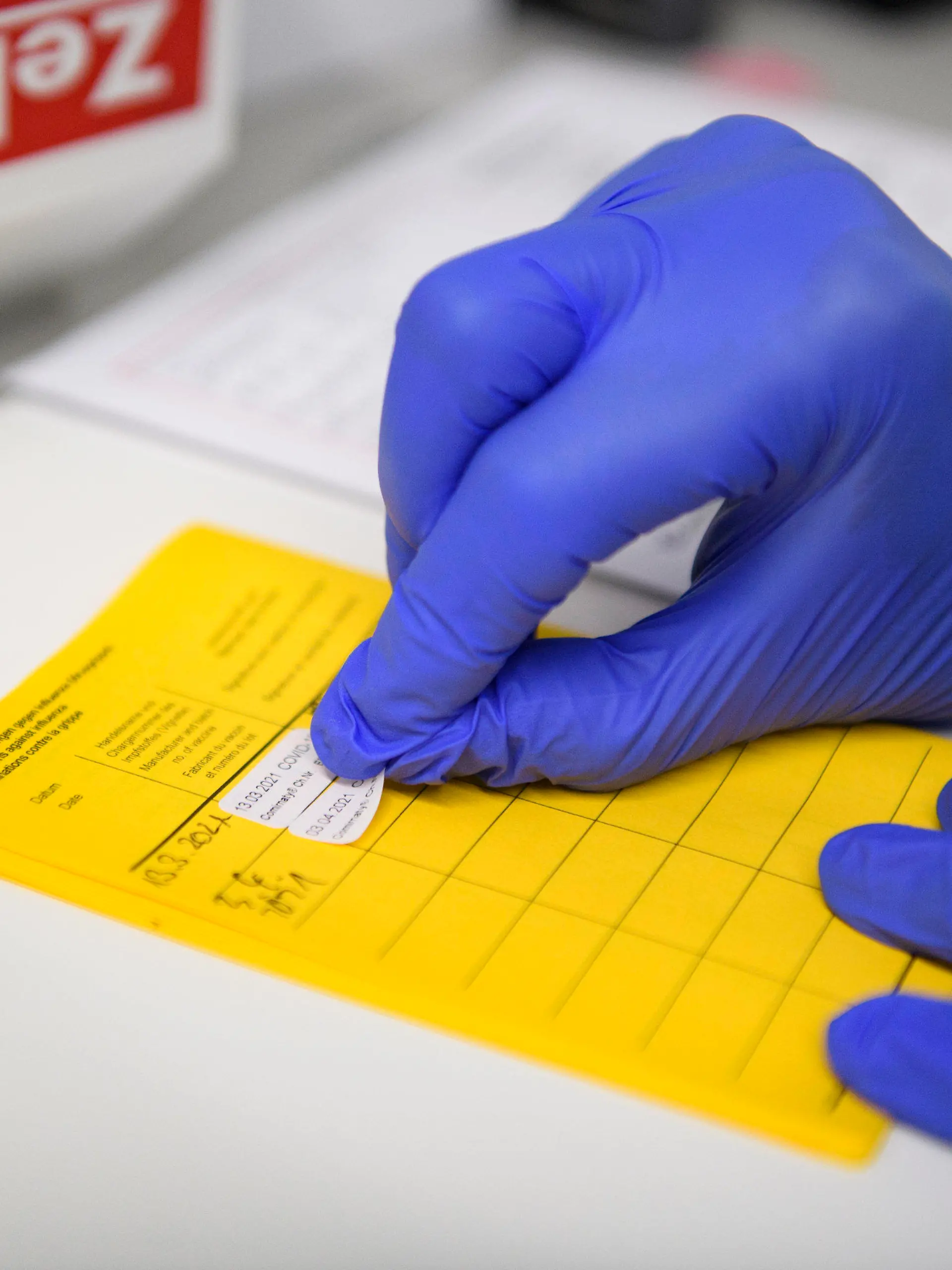 03.04.2021, Nordrhein-Westfalen, Velen: Informationen über die Impfung werden im Impfpass eingetragen. Menschen ab 60 Jahren können ab heute in Nordrhein-Westfalen einen Termin zur Impfung mit dem Wirkstoff von Astrazeneca vereinbaren. Die ersten Über-60-Jährigen wurden sogar schon heute geimpft. Foto: Christopher Neundorf/dpa +++ dpa-Bildfunk +++