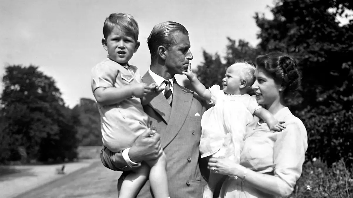 ARCHIV - 09.08.1951, Großbritannien, London: Prinzessin Elizabeth (r), die Prinzessin Anne in den Armen hält, und Prinz Philip, Herzog von Edinburgh, der Prinz Charles trägt, stehen auf dem Gelände von Clarence House. Prinz Philip, Ehemann der britischen Königin Elizabeth II., ist im Alter von 99 Jahren gestorben. Das teilte der Buckingham-Palast am 09.04.2021 in London mit. Foto: Pa/PA Wire/dpa +++ dpa-Bildfunk +++
