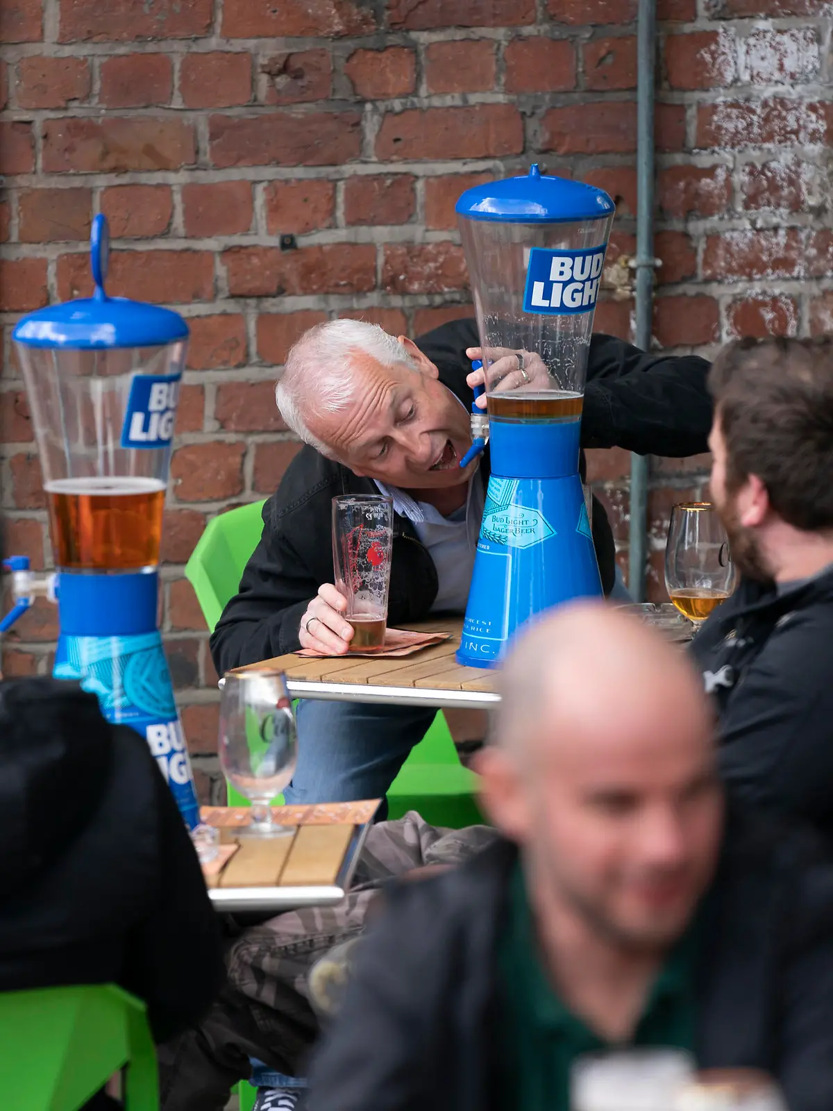 A member of the public pretends to take a swig from a beer tap outside a bar in Manchester Monday, April 12, 2021, as restaurants, bars and pubs can open and serve people who can be seated outside. Millions of people in England will get their first chance in months for haircuts, casual shopping and restaurant meals on Monday, as the government takes the next step on its coronavirus lockdown-lifting road map. (AP Photo Jon Super)