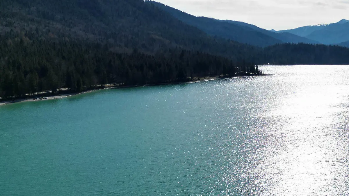 10.04.2023, Bayern, Niedernach: Die Sonne spiegelt sich im Walchensee am frühen Abend bei leichtem Wind und angenehmen Temperaturen. Der Ostermontag lud zu einem Ausflug in die bayerischen Alpen ein. (Aufnahme mit einer Drohne) Foto: Felix Hörhager/dpa +++ dpa-Bildfunk +++