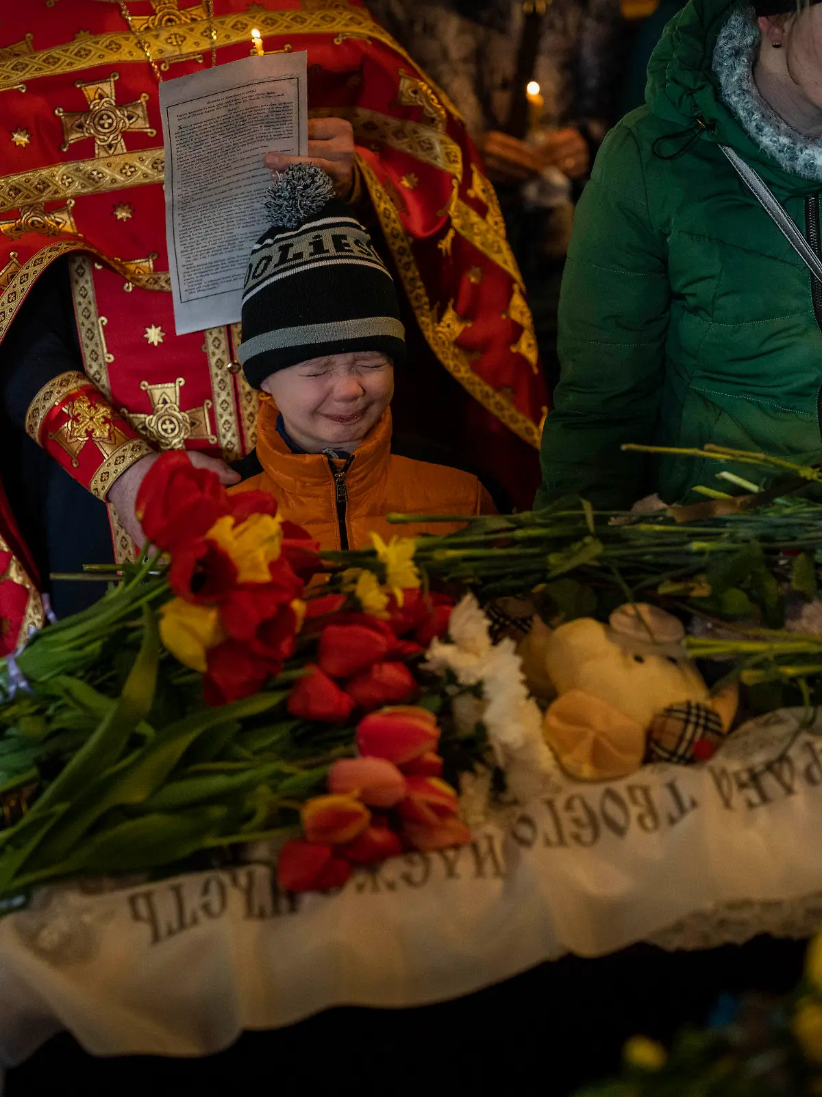 Mykhayl Shulha, center, cries next to the coffin of his sister Sofia Shulha during a funeral prayer in Uman, central Ukraine, Sunday, April 30, 2023. Sofia Shulha, 12, and Pysarev Kiriusha, 18, were killed during a Russian attack on a residential building early Friday morning. (AP Photo/Bernat Armangue)