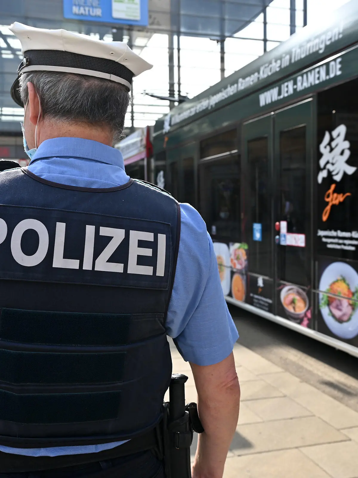 25.03.2021, Thüringen, Erfurt: Ein Polizist steht auf dem Willy-Brandt-Platz vor dem Hauptbahnhof, der von der Thüringer Polizei als gefährlicher Ort eingestuft ist. Thüringens Innenminister stellt am 25. März aktuelle Zahlen zur Entwicklung der Kriminalität in Thüringen vor. Erwartet werden unter anderem Aufschlüsse darüber, wie sich die Fallzahlen in bestimmten Kriminalitätsgebieten im Corona-Jahr 2020 entwickelt haben. Foto: Martin Schutt/dpa-Zentralbild/dpa +++ dpa-Bildfunk +++