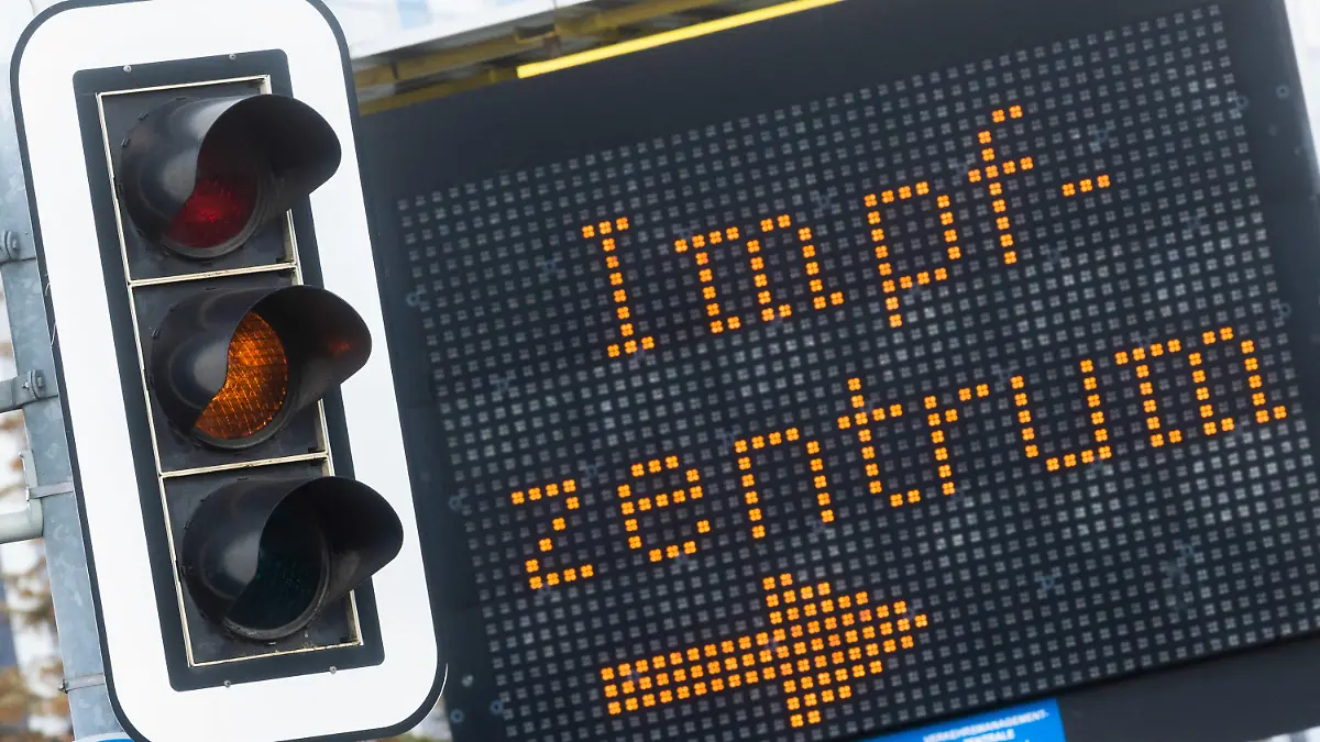 12.04.2021, Niedersachsen, Hannover: Eine elektronische Anzeigetafel mit dem Wort "Impfzentrum" hinter einer Ampel, die auf gelb steht, weist den Weg zum Impfzentrum auf dem Messegelände. Foto: Julian Stratenschulte/dpa +++ dpa-Bildfunk +++