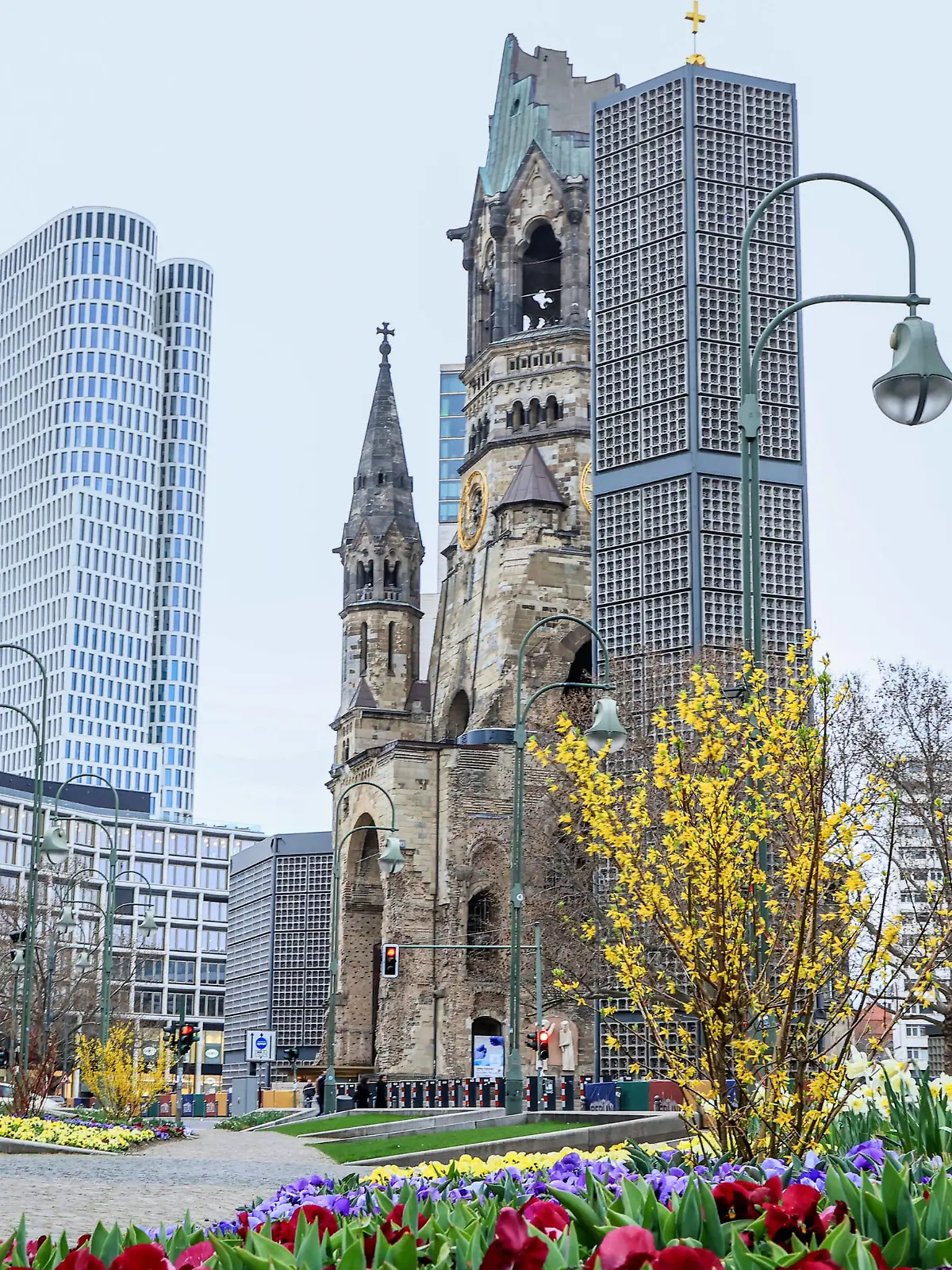  City Berlin Breitscheidplatz Berlin, 02.04.2021: Kaiser-Wilhelm-Gedaechtnis-Kirche neben Hotel Motel One Berlin-Upper West und Waldorf Astoria Berlin. Gelb bewachsenene Pflanzen, Tulpen und Veilchen in Osterzeit vor Gedaechtniskirche. Berlin Berlin Deutschland Breitscheidplatz *** City Berlin Breitscheidplatz Berlin, 02 04 2021 Kaiser Wilhelm Memorial Church next to Hotel Motel One Berlin Upper West and Waldorf Astoria Berlin Yellow overgrown plants, tulips and violets in Easter time in front of Gedaechtniskirche Berlin Berlin Germany Breitscheidplatz