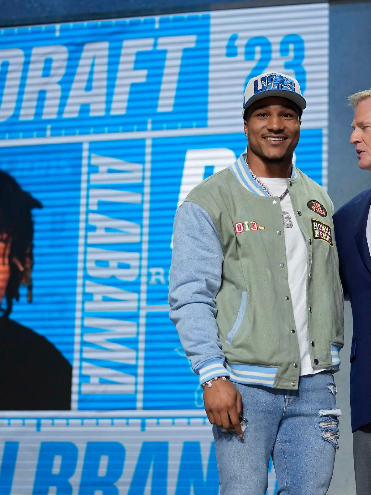 Alabama defensive back Brian Branch, left, stands with NFL Commissioner Roger Goodell after being chosen by the Detroit Lions during the second round of the NFL football draft, Friday, April 28, 2023, in Kansas City, Mo. (AP Photo/Jeff Roberson)