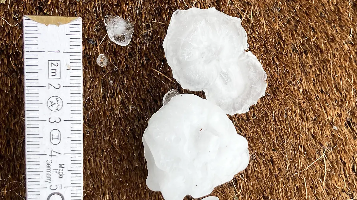 28.04.2023, Rheinland-Pfalz, Mainz: Große Hagelkörner liegen nach einem Unwetter in einem Vorgarten im Stadtteil Ebersheim. Bei wechselhaftem Wetter und einzelnen Gewittern in Rheinland-Pfalz können laut Deutschem Wetterdienst (DWD) starke bis stürmische Böen aufziehen. Foto: Jan Brinkhus/dpa +++ dpa-Bildfunk +++