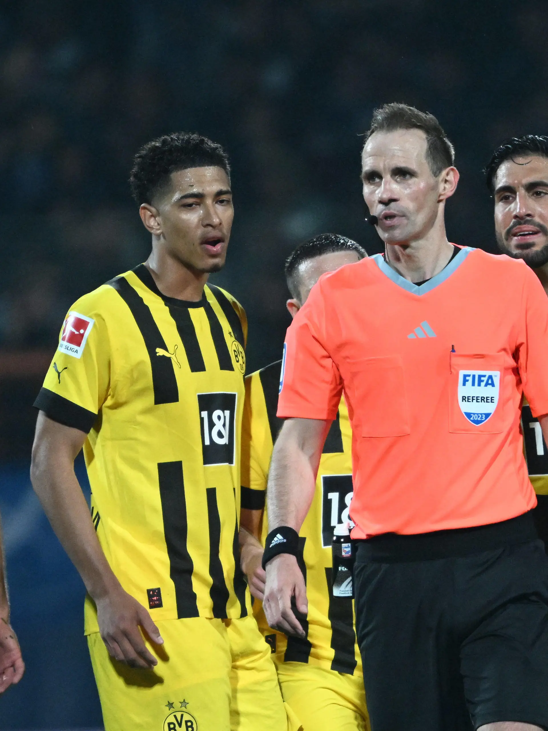 28.04.2023, Nordrhein-Westfalen, Bochum: Fußball: Bundesliga, VfL Bochum - Borussia Dortmund, 30. Spieltag im Vonovia Ruhrstadion, Dortmunds Jude Bellingham und Emre Can (r) appellieren an Schiedsrichter Sascha Stegemann. WICHTIGER HINWEIS: Gemäß den Vorgaben der DFL Deutsche Fußball Liga bzw. des DFB Deutscher Fußball-Bund ist es untersagt, in dem Stadion und/oder vom Spiel angefertigte Fotoaufnahmen in Form von Sequenzbildern und/oder videoähnlichen Fotostrecken zu verwerten bzw. verwerten zu lassen. Foto: Federico Gambarini/dpa +++ dpa-Bildfunk +++