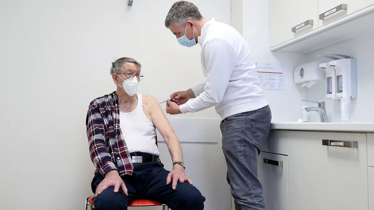 07.04.2021, Sachsen-Anhalt, Schönebeck: Der Hausarzt Robin John (r) verabreicht dem 85-jährigen Hans-Joachim Nettelbeck in einem Behandlungszimmer die erste Impfung mit dem Corona-Impfstoff Comirnaty von Biontech/Pfizer. In Sachsen-Anhalt werden die niedergelassenen Ärzte in die Impfstrategie einbezogen. Foto: Ronny Hartmann/dpa +++ dpa-Bildfunk +++