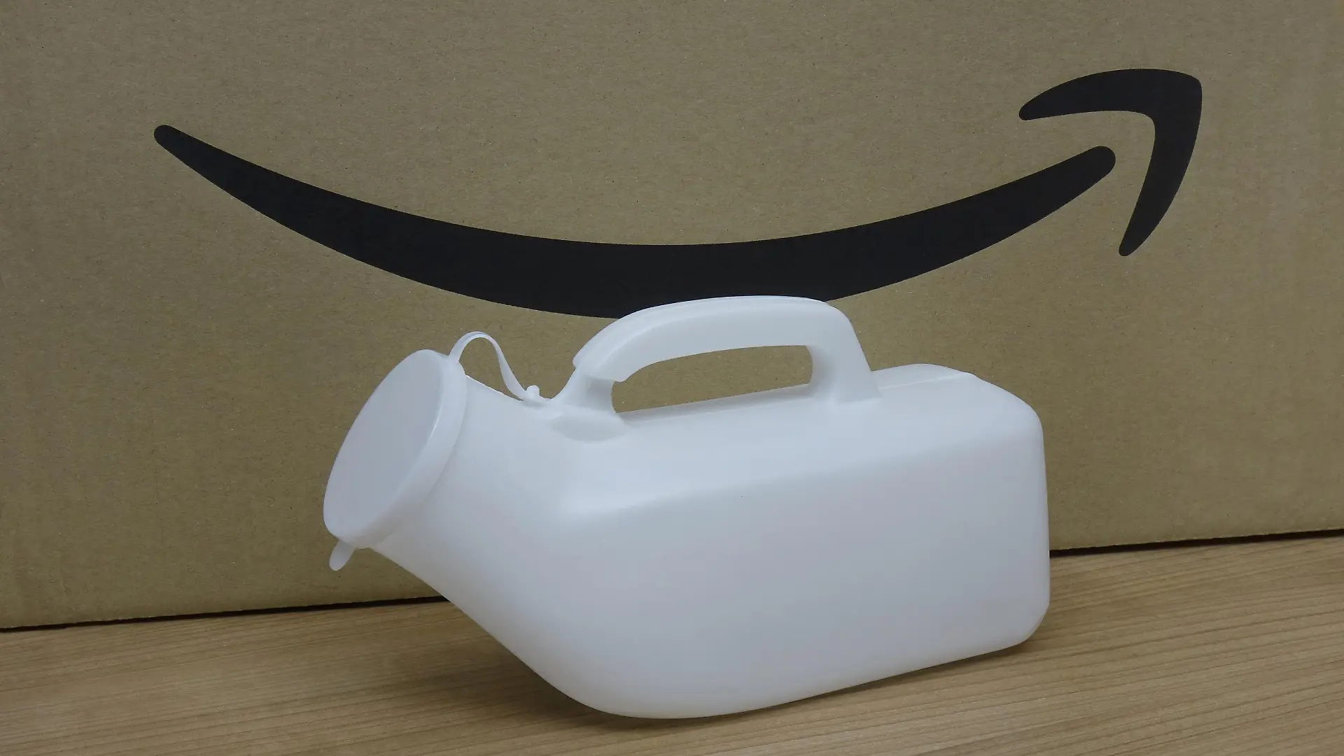 Urinflasche steht vor einem Amazon-Karton.
