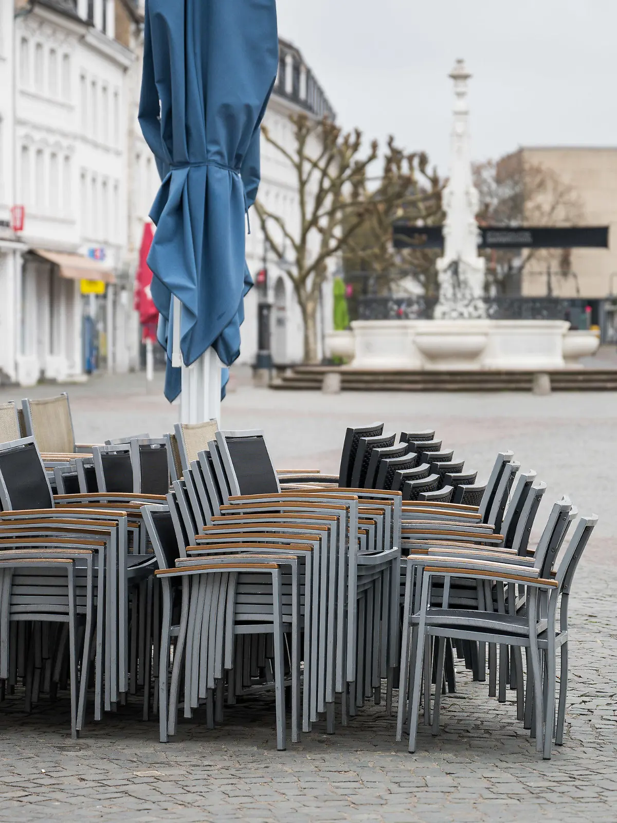 05.04.2021, Saarland, Saarbrücken: In der Innenstadt stehen im Außenbereich einer Gastronomie Stühle. Am morgigen Dienstag darf Außengastronomie unter Auflagen wieder öffnen. Foto: Oliver Dietze/dpa +++ dpa-Bildfunk +++