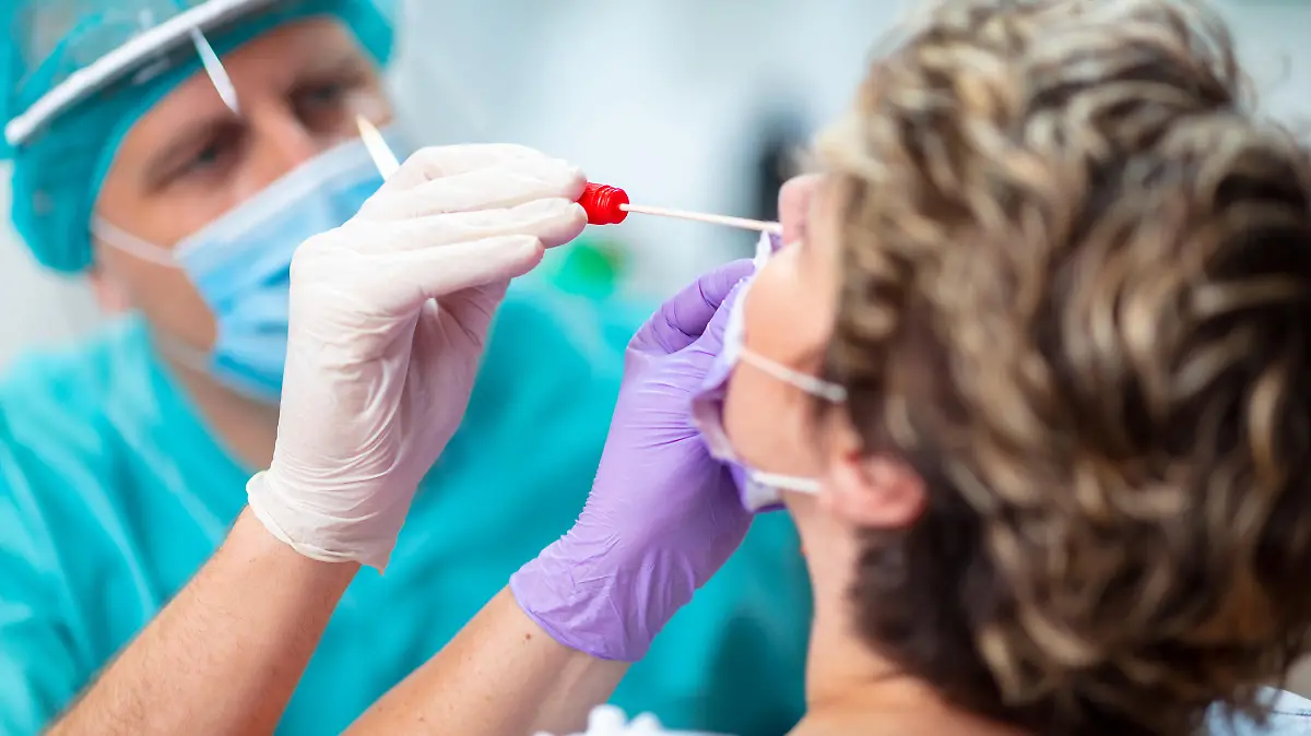 Frau bekommt Coronatest durch die Nase.