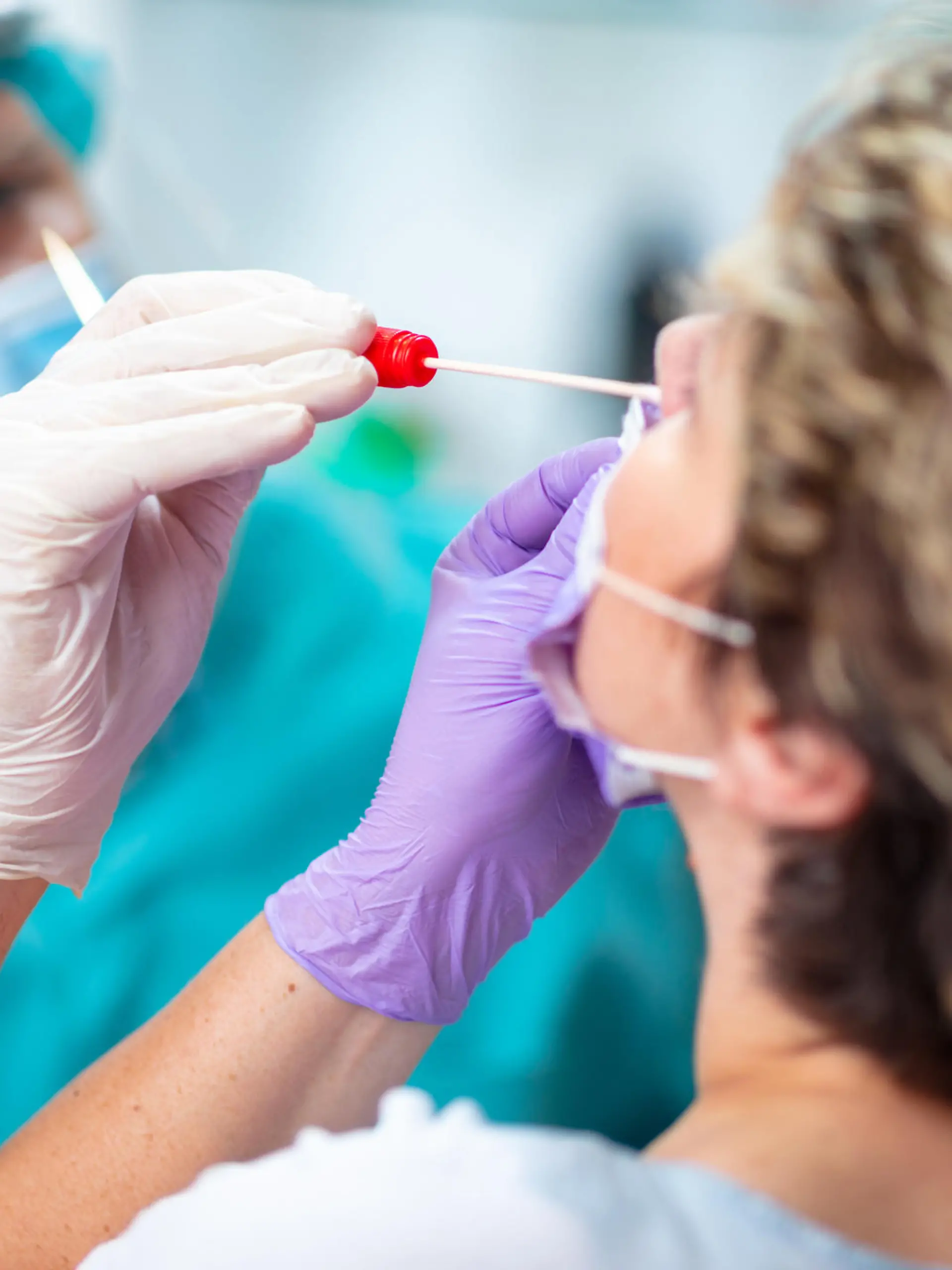 Frau bekommt Coronatest durch die Nase.
