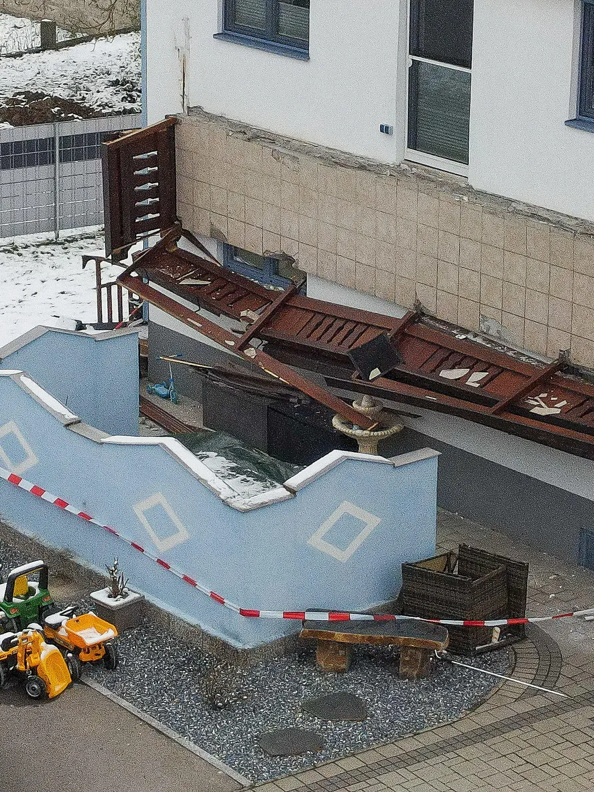 06.04.2021, Österreich, Lenzing: Ein abgestürzter Balkon hängt senkrecht an einer Hauswand. Drei Frauen und ein Kleinkind sind dreieinhalb Meter abgestürzt. Eine 55-Jährige erlag noch am Abend im Krankenhaus ihren lebensgefährlichen Verletzungen, berichtete die Landespolizeidirektion Oberösterreich. Foto: Fotokerschi.At/Werner Kerschbaum/APA/dpa +++ dpa-Bildfunk +++