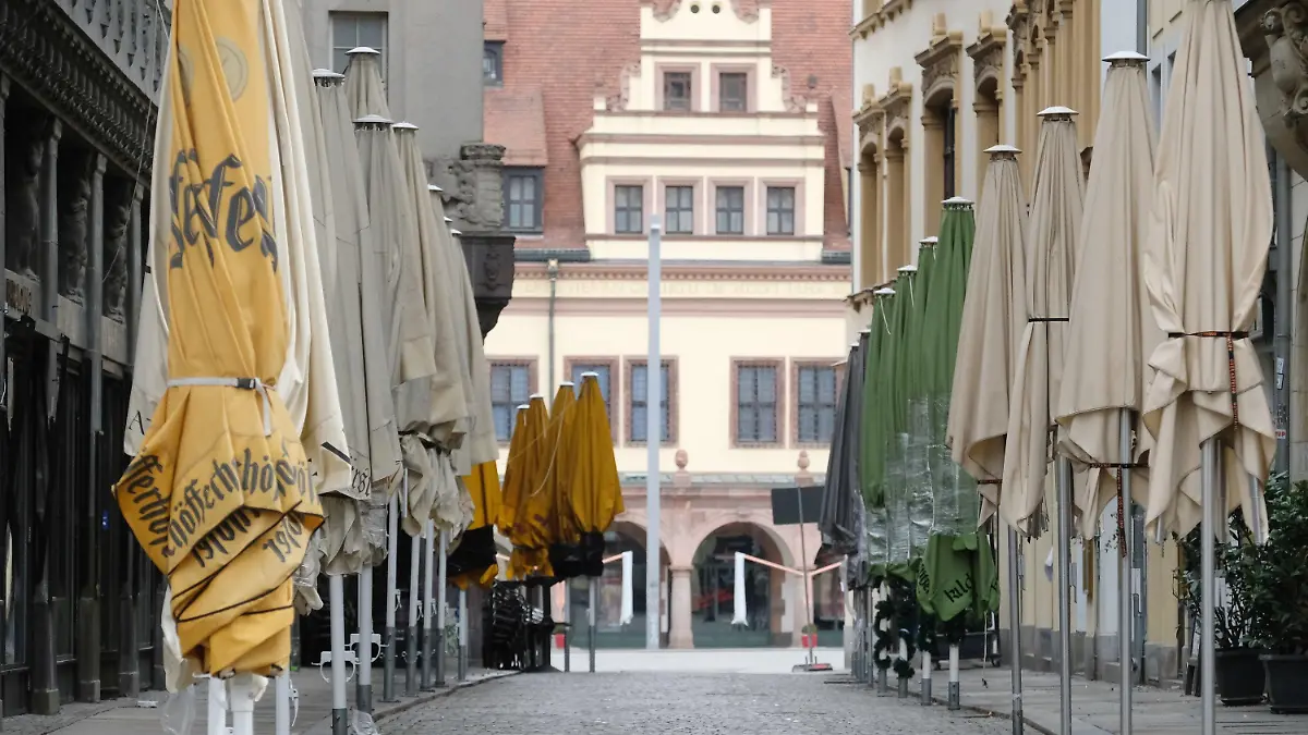 14.03.2021, Sachsen, Leipzig: Geschlossene Schirme stehen vor Lokalen in der menschenleeren Kneipenmeile Barfußgässchen. Foto: Sebastian Willnow/dpa-Zentralbild/dpa +++ dpa-Bildfunk +++