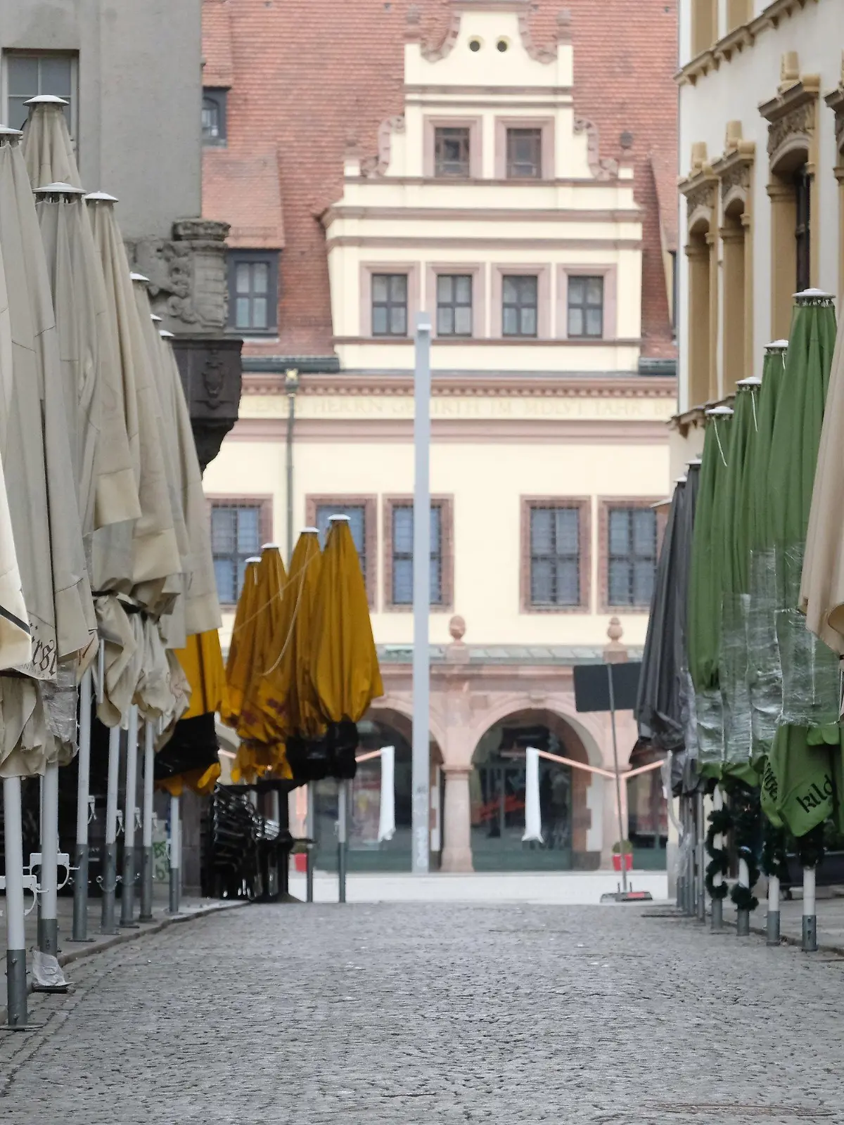 14.03.2021, Sachsen, Leipzig: Geschlossene Schirme stehen vor Lokalen in der menschenleeren Kneipenmeile Barfußgässchen. Foto: Sebastian Willnow/dpa-Zentralbild/dpa +++ dpa-Bildfunk +++
