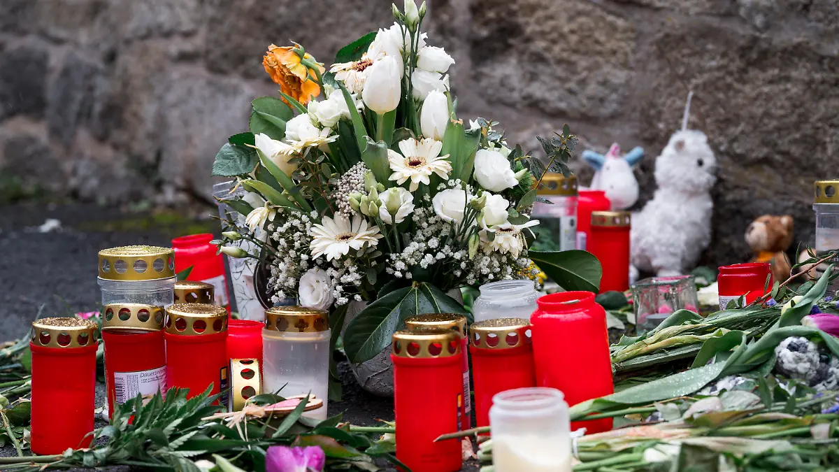 12.04.2023, Bayern, Wunsiedel: An der Straßenecke zur Zufahrtsstraße zum Kinder- und Jugendhilfezentrum, in dem eine Zehnjährige tot aufgefunden wurde, liegen Blumen, Kuscheltiere und Grablichter auf dem Gehweg. Foto: Daniel Vogl/dpa +++ dpa-Bildfunk +++