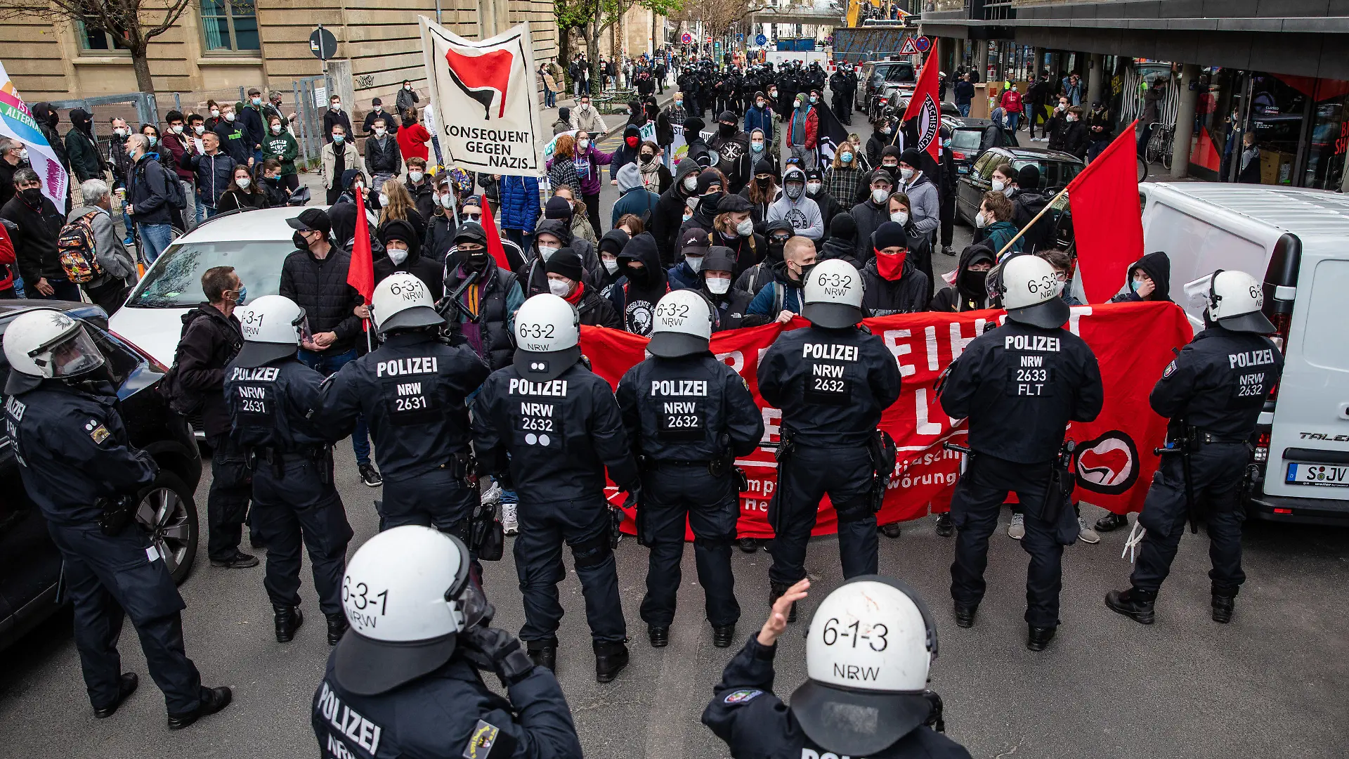 03.04.2021, Baden-Württemberg, Stuttgart: Linke Demonstranten stehen Einsatzkräften der Polizei gegenüber. Die Demo der Linken richtet sich gegen die zeitgleich laufende Demonstration der Initiative «Querdenken». Die Demonstration der Querdenker richtet sich gegen die Pandemie-Einschränkungen der Bundesregierung - Abstandsregeln und das tragen von Masken wurde größtenteils missachtet. Foto: Christoph Schmidt/dpa +++ dpa-Bildfunk +++