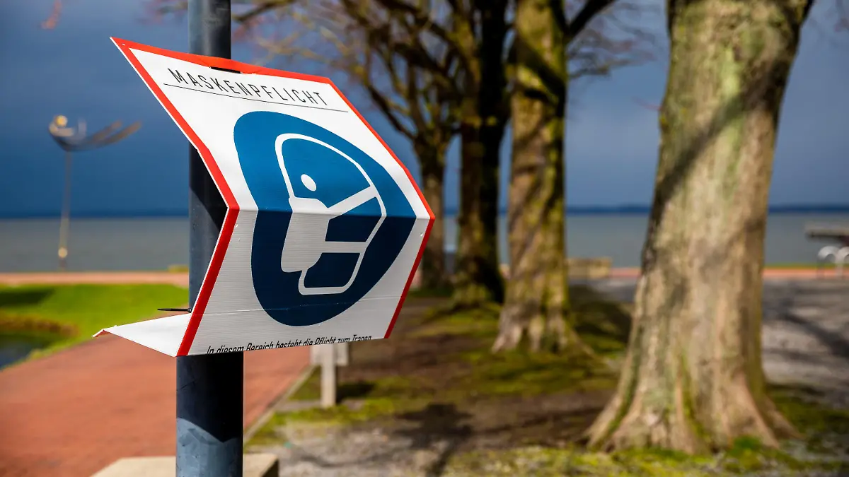 27.03.2021, Niedersachsen, Steinhude: Ein Schild weist am Ufer vom Steinhuder Meer auf die Einhaltung der Maskenpflicht zur Eindämmung der Corona-Panpemie hin. In Niedersachsen haben die Osterferien begonnen. Foto: Moritz Frankenberg/dpa +++ dpa-Bildfunk +++