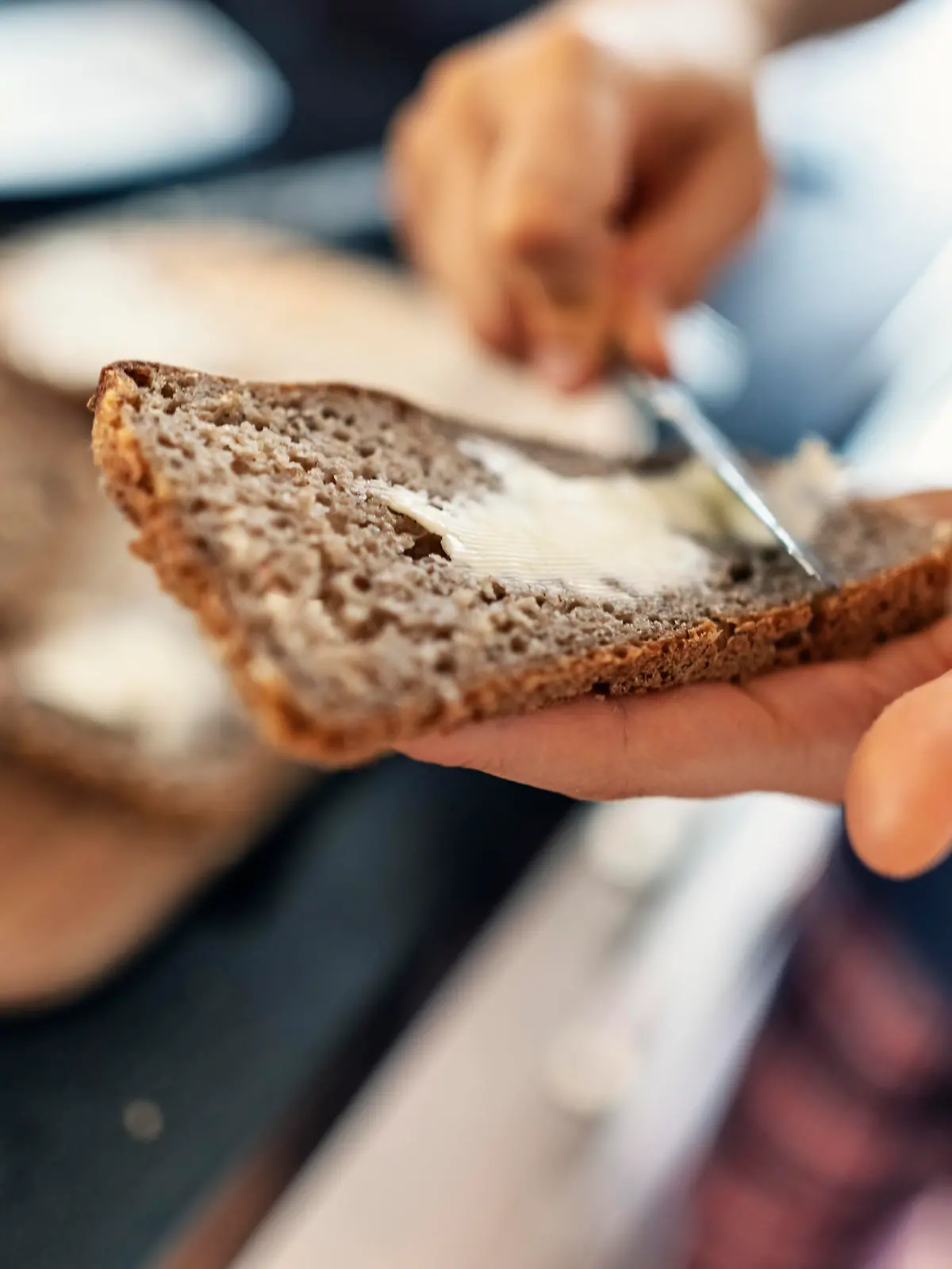 Teenage boy helping to prepare supper for the family. The boy is buttering a fresh slice of delicious sourdough rye bread.
Canon R5