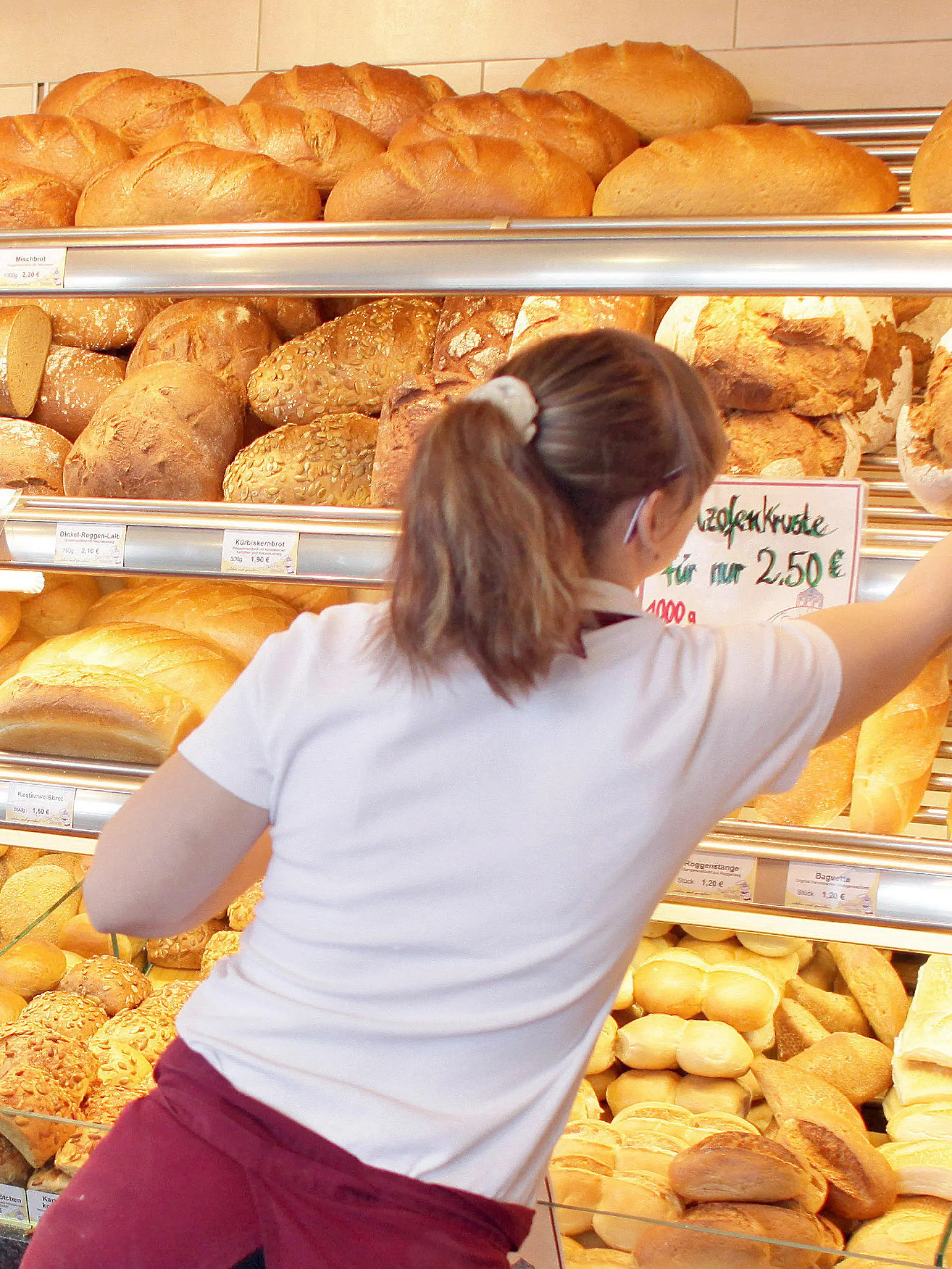 ARCHIV - Eine Verkäuferin greift am 14.03.2011 in einer Filiale einer traditionellen Bäckerei in Zwenkau (Landkreis Leipzig) nach einem Brot. (ZU dpa "Bäcker zwischen Pleite und Finanzinvestoren - Am Bahnhof läuft's" vom 20.09.2017) Foto: Jan Woitas/dpa-Zentralbild/dpa +++(c) dpa - Bildfunk+++
