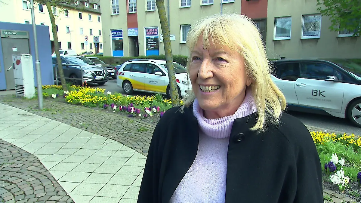 Birgit Matzel steht vor ihrem bepflanzen Blumenbeet