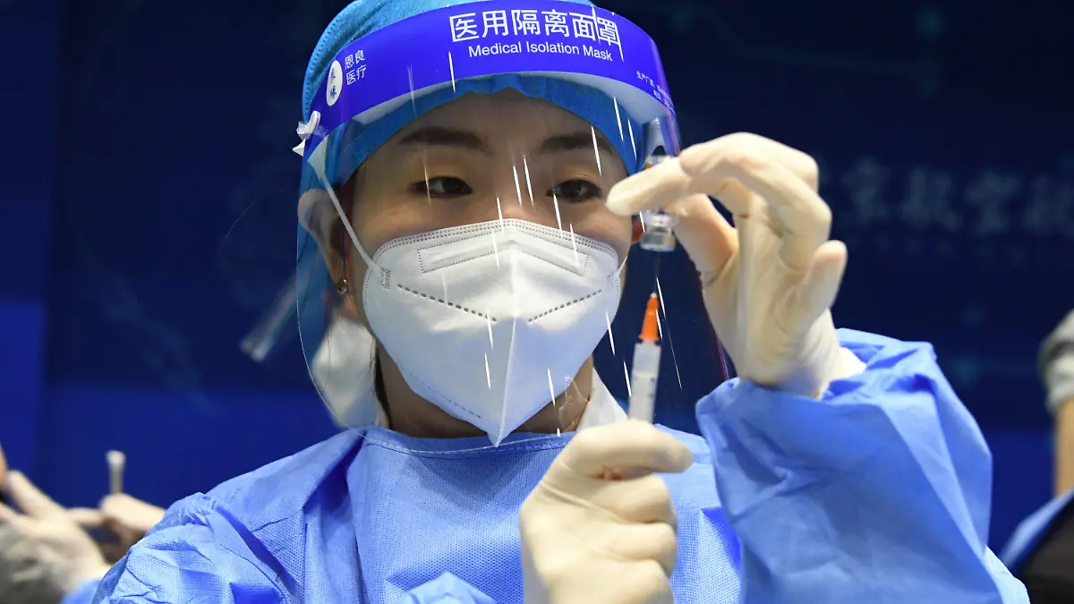 24.03.2021, China, Peking: Eine Mitarbeiterin im Gesundheitswesen bereitet an der Beihang-Universität eine Spritz mit einem Corona-Impfstoff vor. Foto: Ren Chao/Xinhua/dpa +++ dpa-Bildfunk +++