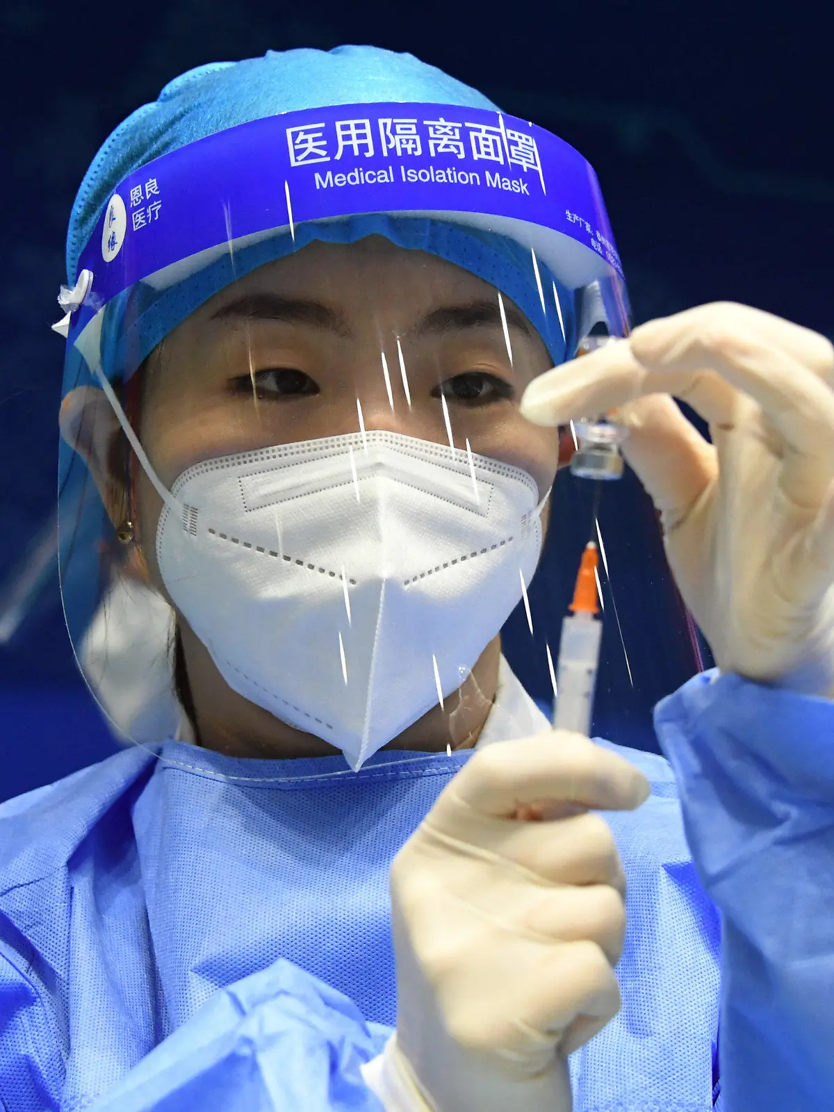 24.03.2021, China, Peking: Eine Mitarbeiterin im Gesundheitswesen bereitet an der Beihang-Universität eine Spritz mit einem Corona-Impfstoff vor. Foto: Ren Chao/Xinhua/dpa +++ dpa-Bildfunk +++