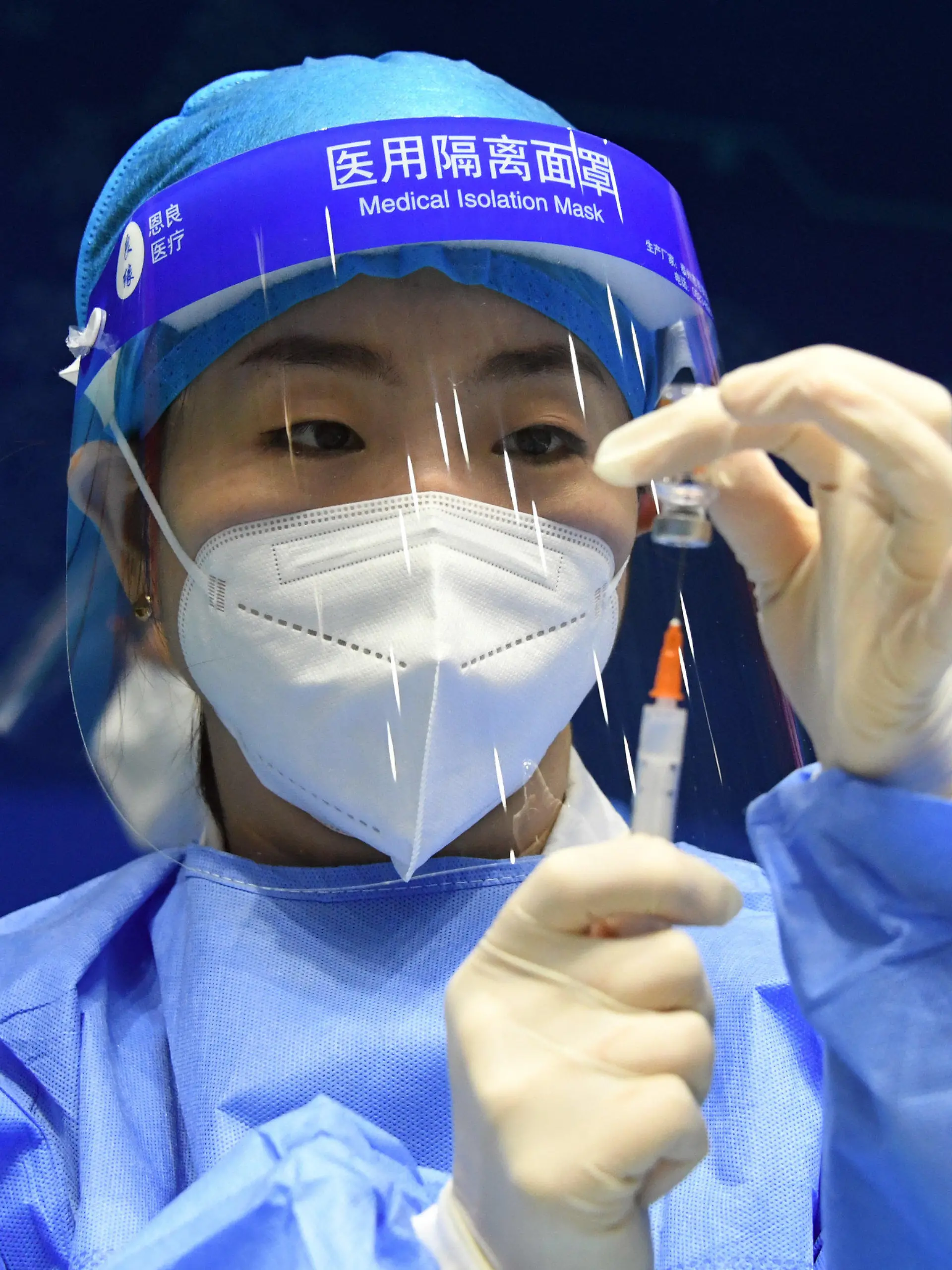 24.03.2021, China, Peking: Eine Mitarbeiterin im Gesundheitswesen bereitet an der Beihang-Universität eine Spritz mit einem Corona-Impfstoff vor. Foto: Ren Chao/Xinhua/dpa +++ dpa-Bildfunk +++