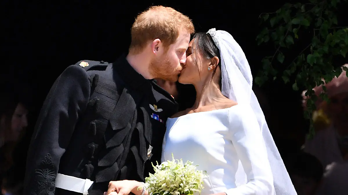 ARCHIV - 19.05.2018, Großbritannien, Windsor: Prinz Harry, Herzog von Sussex und seine Frau Herzogin Meghan küssen sich nach ihrer Trauung vor der St.-George-Kapelle im Schloss Windsor. Ein ehemaliger ranghoher Kirchenmitarbeiter hat Angaben von Herzogin Meghan über eine vorgezogene heimliche Hochzeit mit Prinz Harry widersprochen. (zu dpa: «Ex-Kirchenmitarbeiter: Keine heimliche Hochzeit von Meghan und Harry») Foto: Ben Stansall/PA Wire/dpa +++ dpa-Bildfunk +++