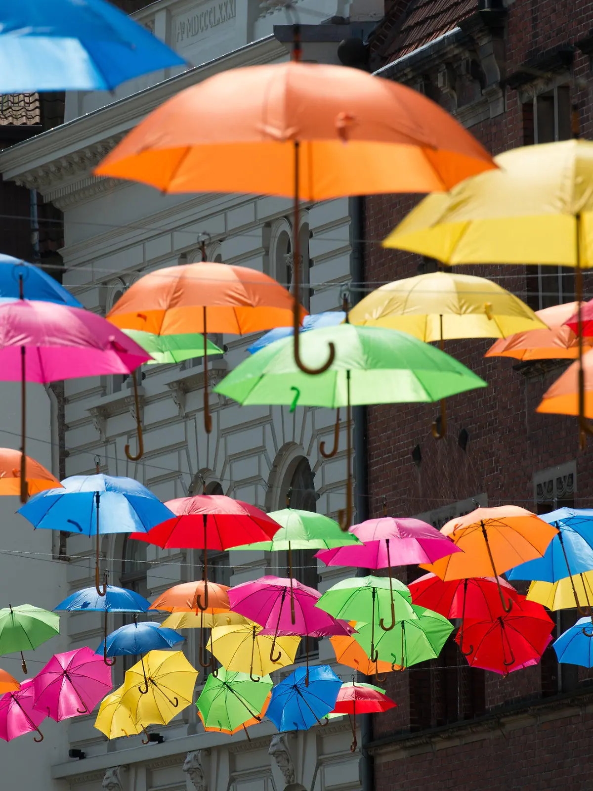 Bunte Regenschirme hängen am 18.05.2016 in einer Gasse in der Altstadt von Lübeck (Schleswig-Holstein). Die Schirme sind Teil der Dekoration für das Hansekultur-Festivals, das vom 20. bis zum 22. Mai in der Hansestadt stattfindet. Foto: Daniel Reinhardt/dpa +++(c) dpa - Bildfunk+++