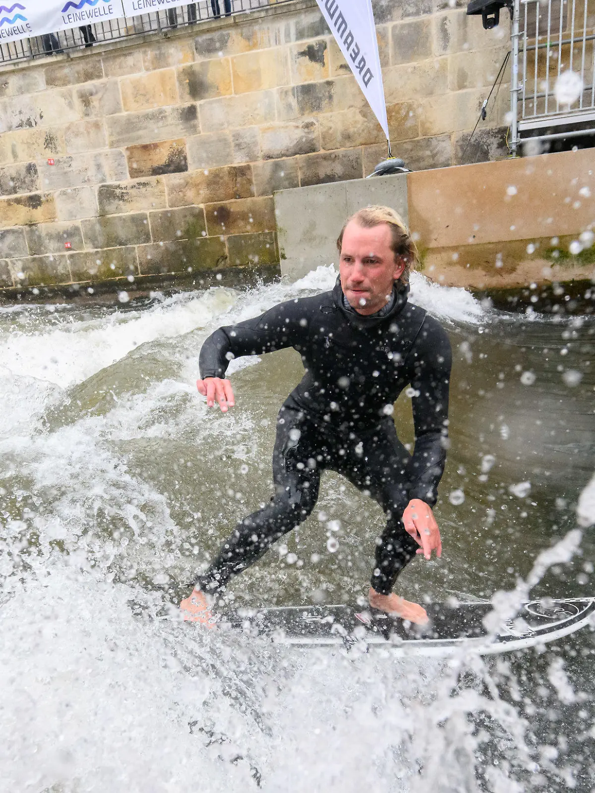 28.04.2023, Niedersachsen, Hannover: Surfer Maurice Friedrich testet die Leinewelle auf dem Fluss Leine in der Altstadt. Die Leinewelle - ein Sportangebot auf einer künstlich erzeugten Welle - wurde nun offiziell eröffnet. Vom 05. bis 07.05.23 findet hier die Deutsche Meisterschaft im ·Rapid Surfing·, dem Surfen auf einer künstlichen Welle, statt. Foto: Julian Stratenschulte/dpa +++ dpa-Bildfunk +++