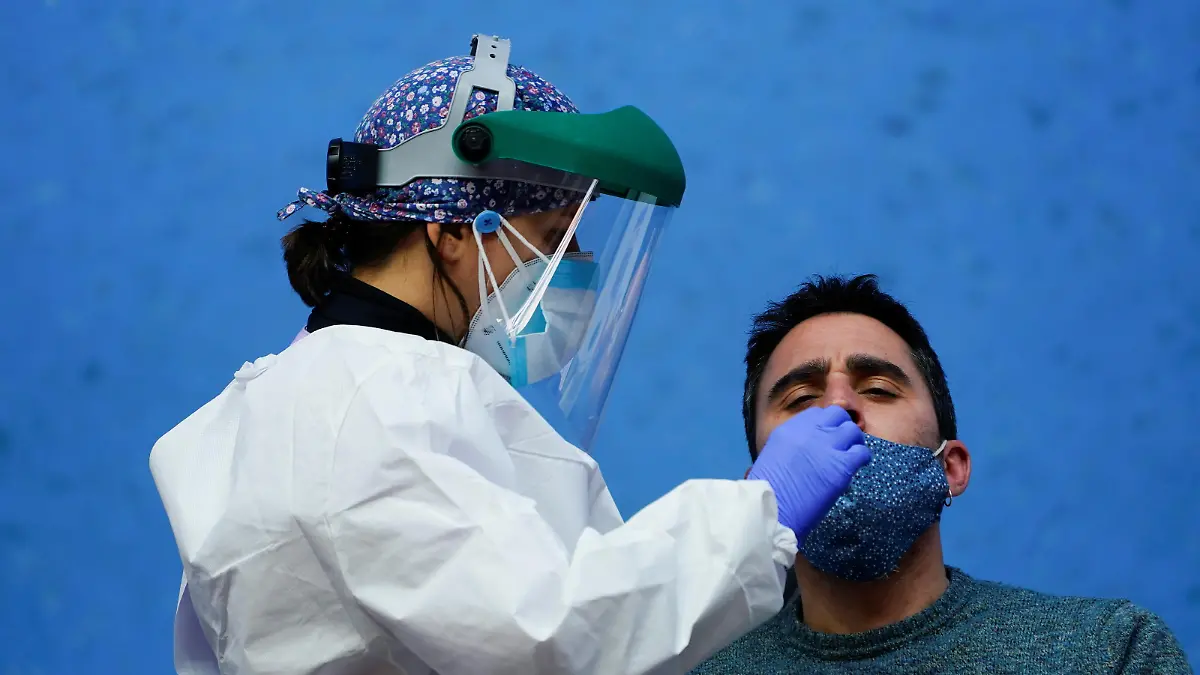 A nurse conducts a PCR (polymerase chain reaction) swab test on a resident of the Basque town of Elorrio during mass testing, following an upsurge of coronavirus disease (COVID-19) cases in the municipality, in Elorrio, Spain March 23, 2021. REUTERS/Vincent West