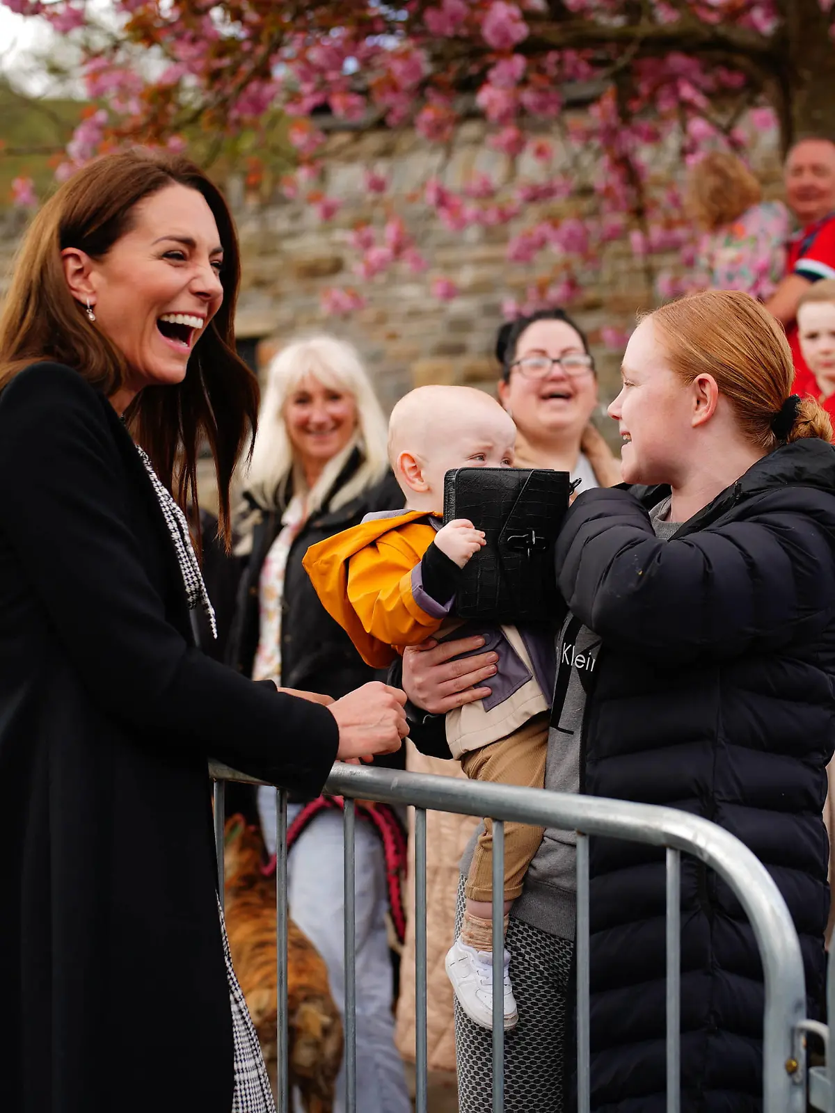 Entertainment Bilder des Tages . 28/04/2023. Aberfan, United Kingdom. A child plays with the handbag of Kate Middleton, the Princess of Wales , during a visit to the Aberfan memorial garden in Wales,United Kingdom, to pay her respects to those who lost their lives during the Aberfan disaster in 1966. PUBLICATIONxINxGERxSUIxAUTxHUNxONLY xPoolx/xi-Imagesx IIM-24325-0016