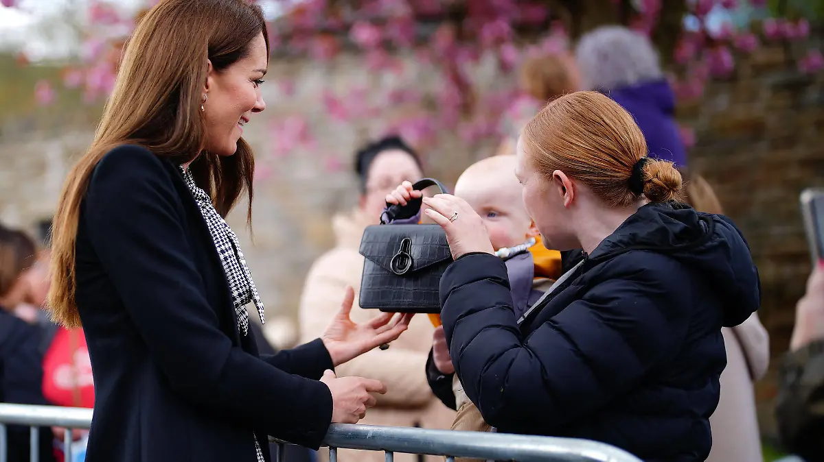 . 28/04/2023. Aberfan, United Kingdom. A child plays with the handbag of Kate Middleton, the Princess of Wales , during a visit to the Aberfan memorial garden in Wales,United Kingdom, to pay her respects to those who lost their lives during the Aberfan disaster in 1966. PUBLICATIONxINxGERxSUIxAUTxHUNxONLY xPoolx/xi-Imagesx IIM-24325-0005