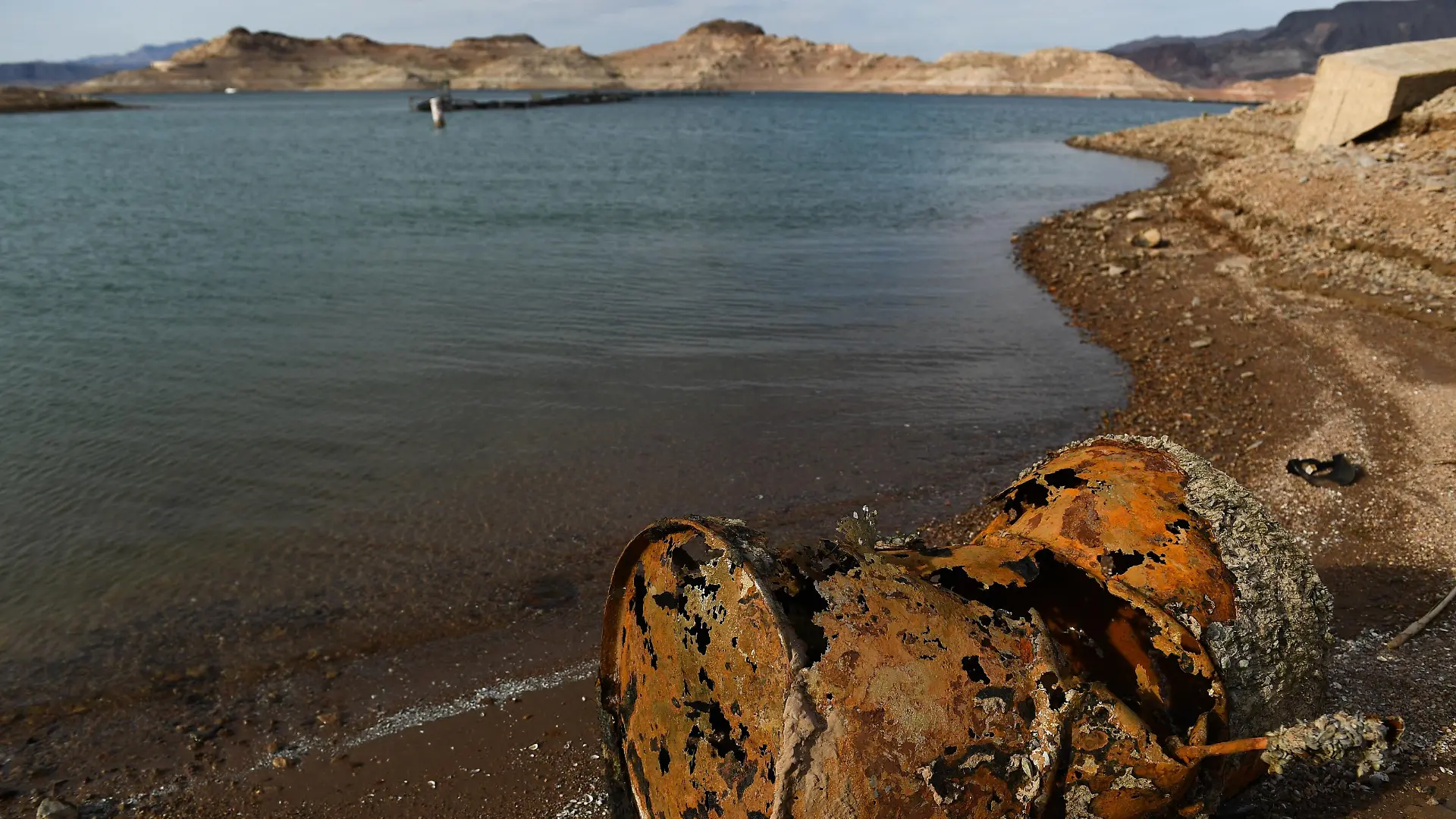A rusted metal barrel, near the location of where a different barrel was found containing a human body, sits exposed on shore during low water levels due to the western drought at the Lake Mead Marina on the Colorado River in Boulder City, Nevada on May 5, 2022. - A worsening drought has revealed a four-decade-old body dumped in Lake Mead, police said May 2, 2022, warning that falling water levels would lead to the uncovering of more corpses. Boaters on Lake Mead near Las Vegas discovered a corroded barrel with its sinister contents during a weekend pleasure trip. (Photo by Patrick T. FALLON / AFP) (Photo by PATRICK T. FALLON/AFP via Getty Images)
