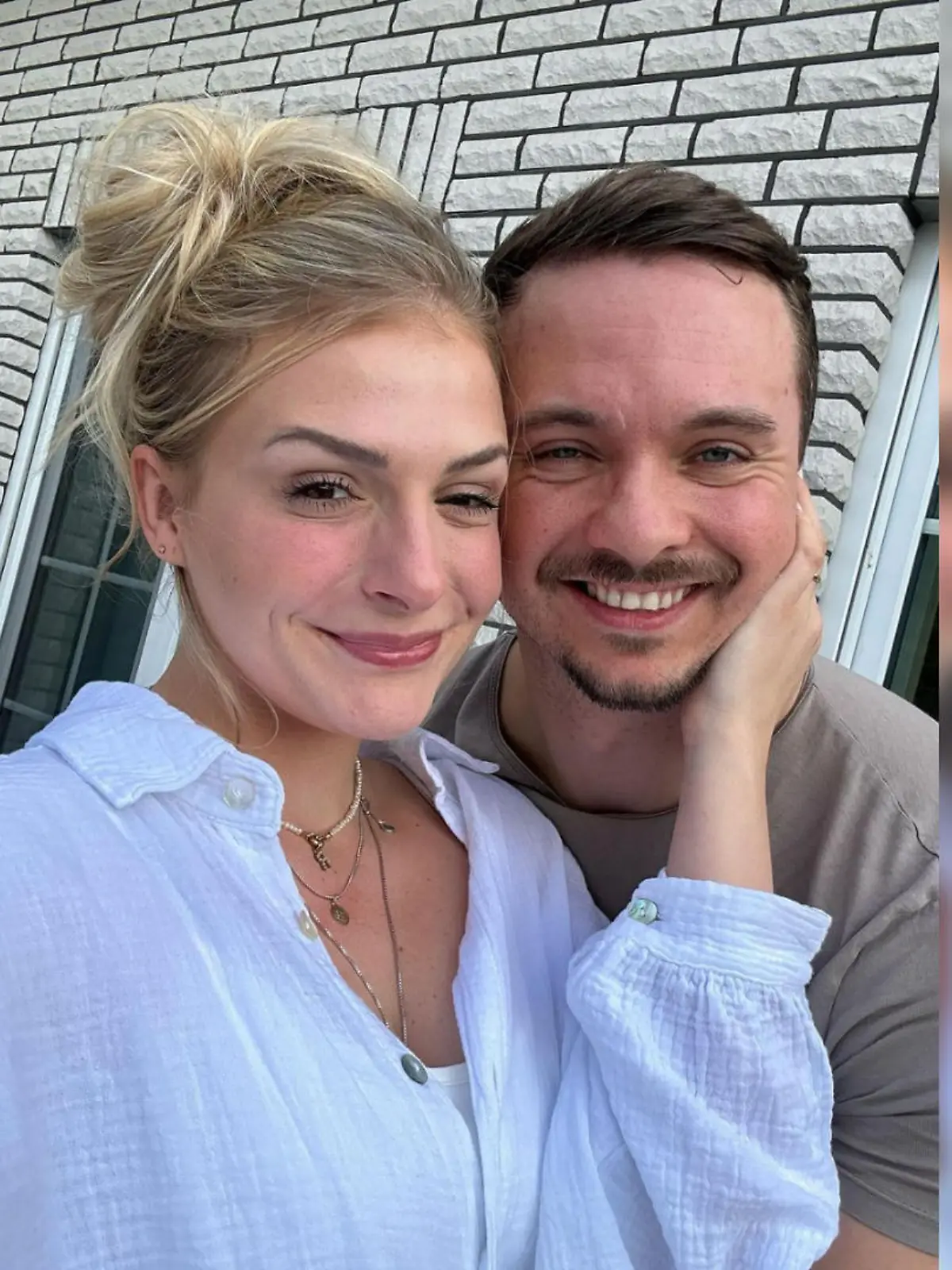 Selfie von Healthy Mandy und FitnessOskar, auf dem beide in die Kamera lächeln. Mandy fasst mit ihrer Hand an Oskars Wange.