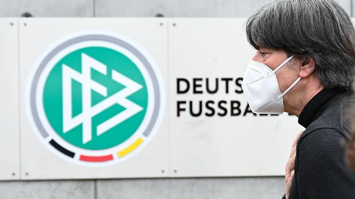 11.03.2021, Hessen, Frankfurt/Main: Bundestrainer Joachim Löw geht nach einem Statement vor der Zentrale des Deutschen Fußball-Bundes (DFB) an dem DFB-Logo und dem Schriftzug «Deutscher Fussball-Bund» vorbei. Löw hatte in einer Video-Pressekonferenz die Gründe für seinen Rücktritt nach der EM erklärt. Foto: Arne Dedert/dpa - WICHTIGER HINWEIS: Gemäß den Vorgaben der DFL Deutsche Fußball Liga bzw. des DFB Deutscher Fußball-Bund ist es untersagt, in dem Stadion und/oder vom Spiel angefertigte Fotoaufnahmen in Form von Sequenzbildern und/oder videoähnlichen Fotostrecken zu verwerten bzw. verwerten zu lassen. +++ dpa-Bildfunk +++