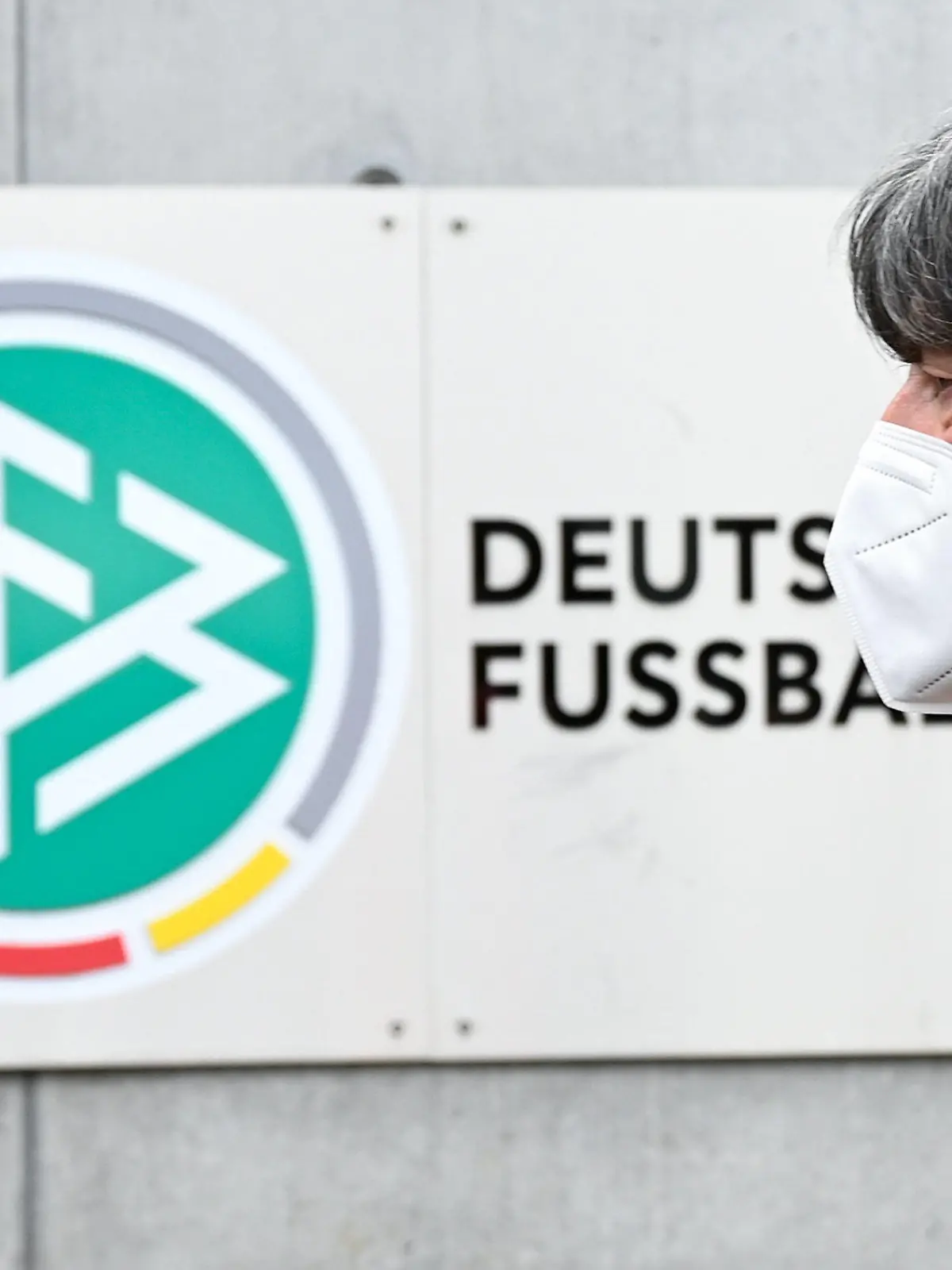 11.03.2021, Hessen, Frankfurt/Main: Bundestrainer Joachim Löw geht nach einem Statement vor der Zentrale des Deutschen Fußball-Bundes (DFB) an dem DFB-Logo und dem Schriftzug «Deutscher Fussball-Bund» vorbei. Löw hatte in einer Video-Pressekonferenz die Gründe für seinen Rücktritt nach der EM erklärt. Foto: Arne Dedert/dpa - WICHTIGER HINWEIS: Gemäß den Vorgaben der DFL Deutsche Fußball Liga bzw. des DFB Deutscher Fußball-Bund ist es untersagt, in dem Stadion und/oder vom Spiel angefertigte Fotoaufnahmen in Form von Sequenzbildern und/oder videoähnlichen Fotostrecken zu verwerten bzw. verwerten zu lassen. +++ dpa-Bildfunk +++