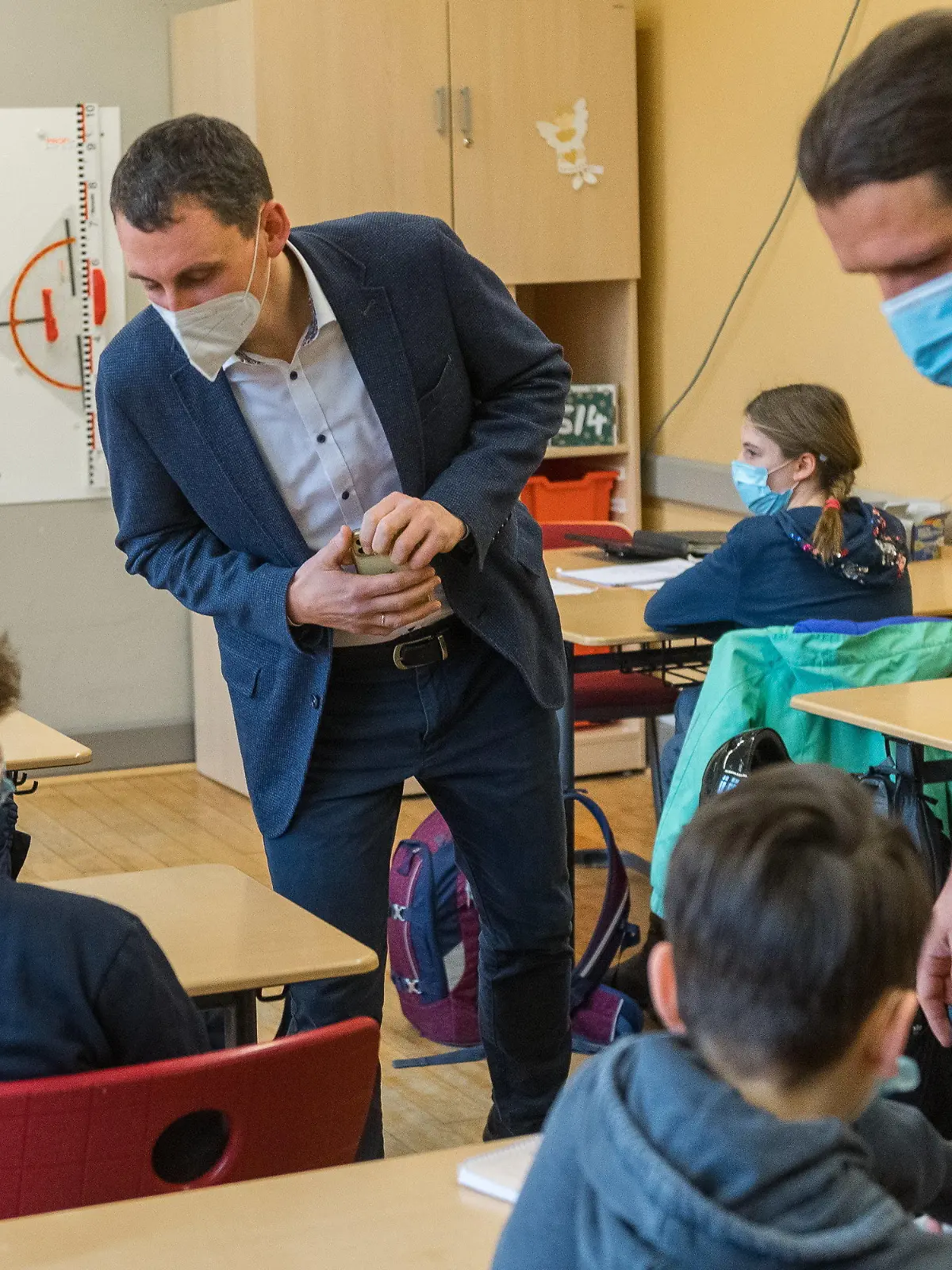 22.03.2021, Sachsen-Anhalt, Halle (Saale): Jakob Meier, Klassenlehrer am Lyonel Feininger Gymnasium, und Schulleiter Jan Riedel (l) überprüfen in einer Klasse die Ergebnisse von Corona Schnelltests. Zum ersten Mal werden in der Schule auf Initiative des Schulleiters Schnelltests für und von den Schülern durchgeführt. Foto: Holger John/dpa-Zentralbild/dpa +++ dpa-Bildfunk +++