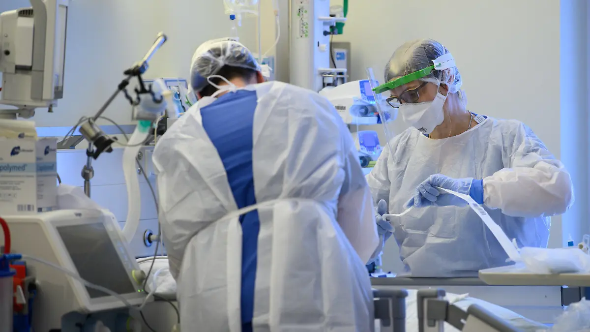 ARCHIV - 19.01.2021, Sachsen, Pulsnitz: Intensivpflegerinnen sind auf der Covid-19 Intensivstation in der VAMED Klinik Schloss Pulsnitz mit der Versorgung von Corona-Patienten beschäftigt. Die Corona-Lage in Deutschland bleibt mit mehr als 9000 Neuinfektionen angespannt - und Intensivmedizinern bereitet die möglicherweise krankmachendere Variante B.1.1.7 Sorgen. (zu dpa «Intensivmediziner weiter unter Druck - Mehr als 9000 Neuinfektionen») Foto: Robert Michael/dpa-Zentralbild/dpa +++ dpa-Bildfunk +++