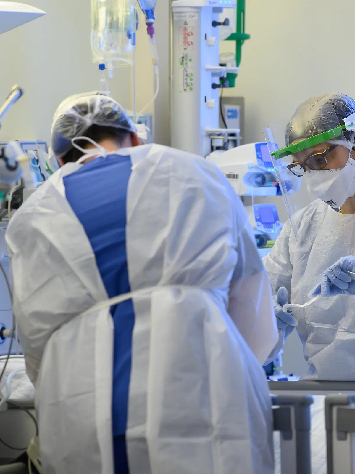 ARCHIV - 19.01.2021, Sachsen, Pulsnitz: Intensivpflegerinnen sind auf der Covid-19 Intensivstation in der VAMED Klinik Schloss Pulsnitz mit der Versorgung von Corona-Patienten beschäftigt. Die Corona-Lage in Deutschland bleibt mit mehr als 9000 Neuinfektionen angespannt - und Intensivmedizinern bereitet die möglicherweise krankmachendere Variante B.1.1.7 Sorgen. (zu dpa «Intensivmediziner weiter unter Druck - Mehr als 9000 Neuinfektionen») Foto: Robert Michael/dpa-Zentralbild/dpa +++ dpa-Bildfunk +++