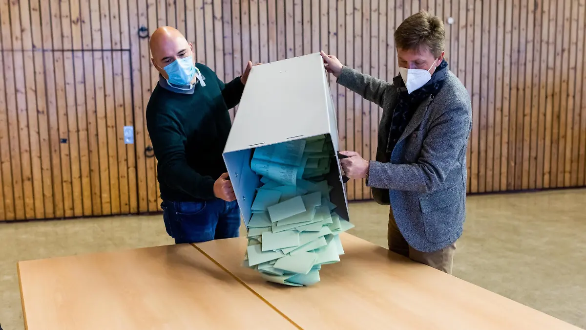 14.03.2021, Baden-Württemberg, Feldberg: Wahlhelfer schütten eine Urne mit Stimmzetteln auf einem Tisch zur Auszählung aus. Die Feldberghalle im Feldberger Ortsteil Altglashütten ist eines der höchsten Wahllokale Baden-Württembergs. Die Wahlbeteiligung in dem Ort lag bei knapp 66 Prozent. Foto: Philipp von Ditfurth/dpa +++ dpa-Bildfunk +++