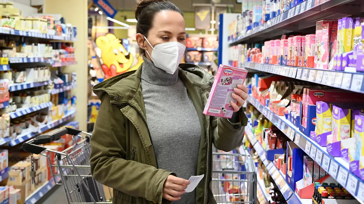 Eine Frau mit Mund Nasenschutz Maske vom Typ FFP2 beim Einkaufen.