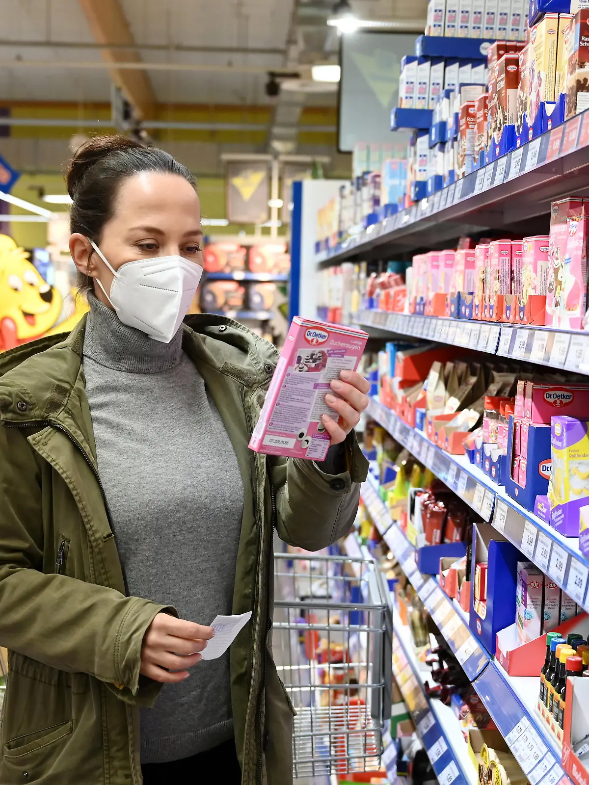 Eine Frau mit Mund Nasenschutz Maske vom Typ FFP2 beim Einkaufen.